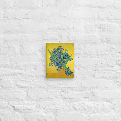 Van Gogh's 'Vase with Irises Against a Yellow Background' on a 8"x10" unframed canvas print on a white brick wall.