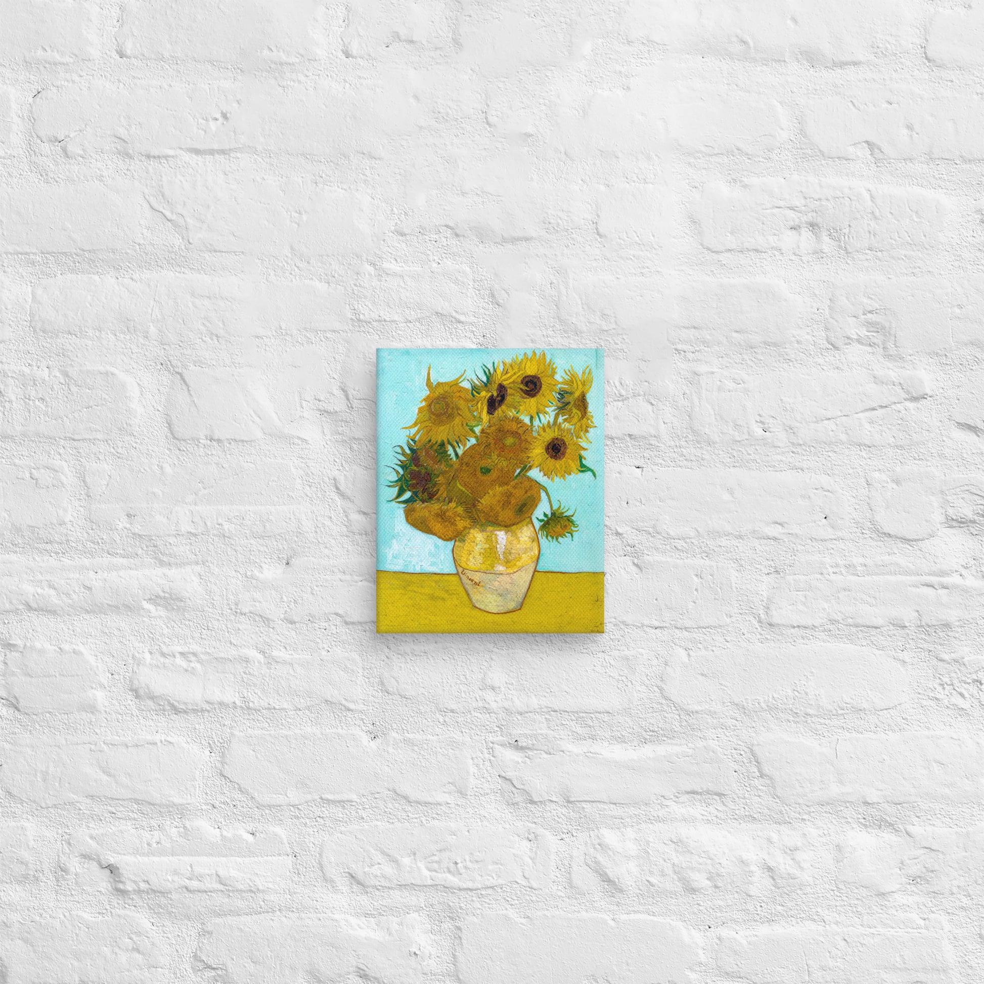 Van Gogh's 'Vase with Twelve Sunflowers' on a 8"x10" unframed canvas print on a white brick wall.