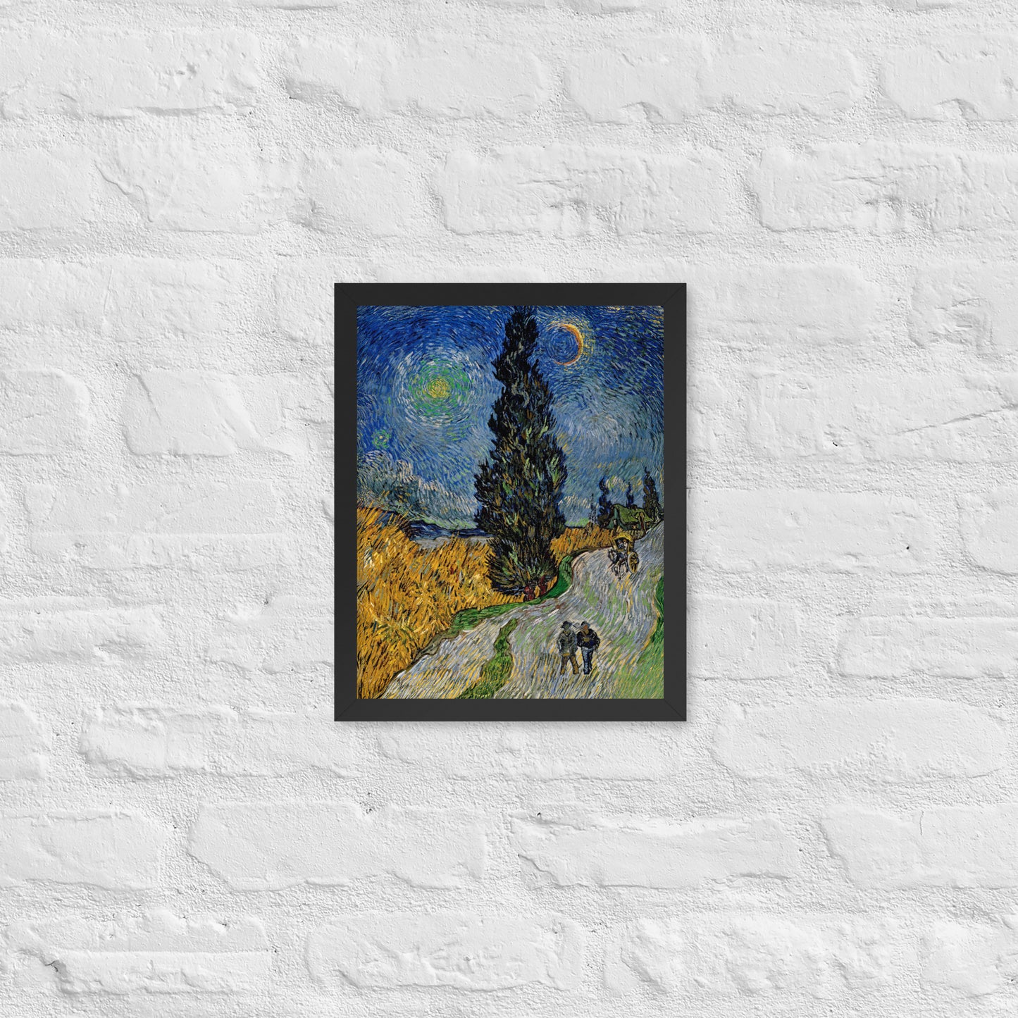 Van Gogh's 'Road with Cypress and Star' on a 11"x14" black framed poster print on a white brick wall.