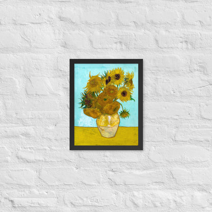 Van Gogh's 'Vase with Twelve Sunflowers' on a 11"x14" black framed poster print on a white brick wall.