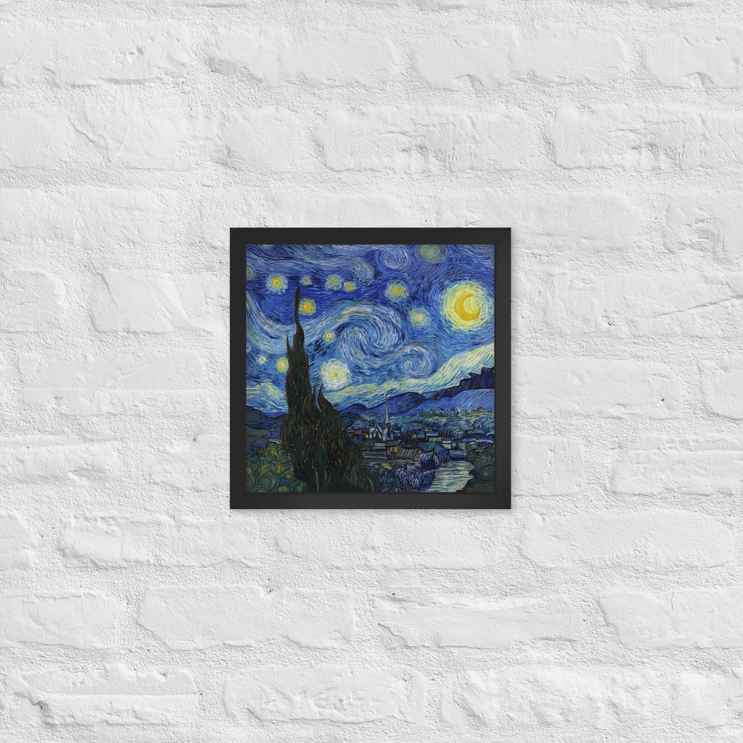 Van Gogh's 'Starry Night' on a 12"x12" black framed poster print on a white brick wall.