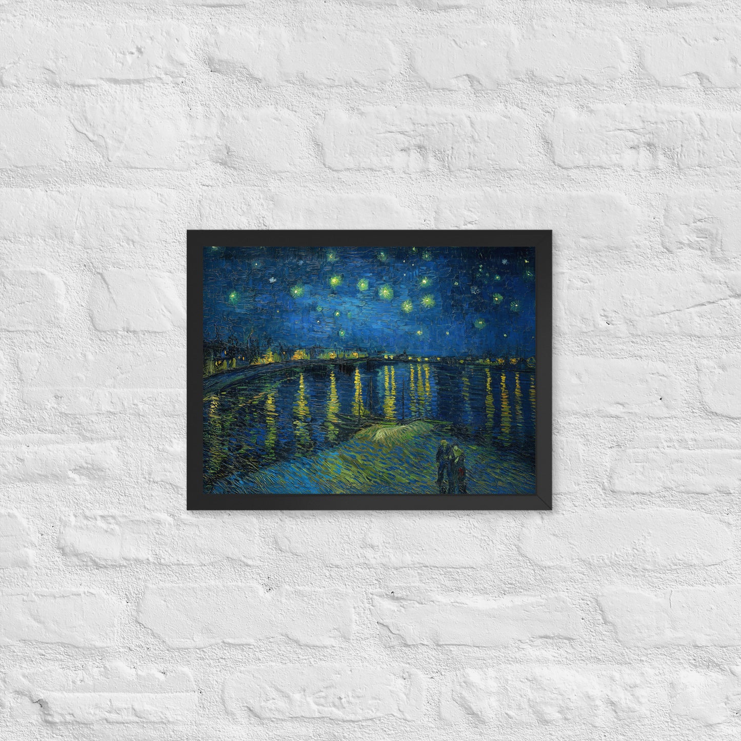 Van Gogh's 'Starry Night Over the Rhone' on a 12"x16" black framed poster print on a white brick wall.