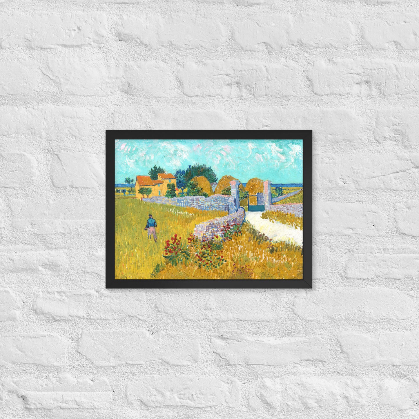 Van Gogh's 'Farmhouse in Provence' on a 12"x16" black framed poster print on a white brick wall.