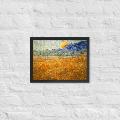 Van Gogh's 'Landscape with Wheat Sheaves and Rising Moon' on a 12"x16" black framed poster print on a white brick wall.