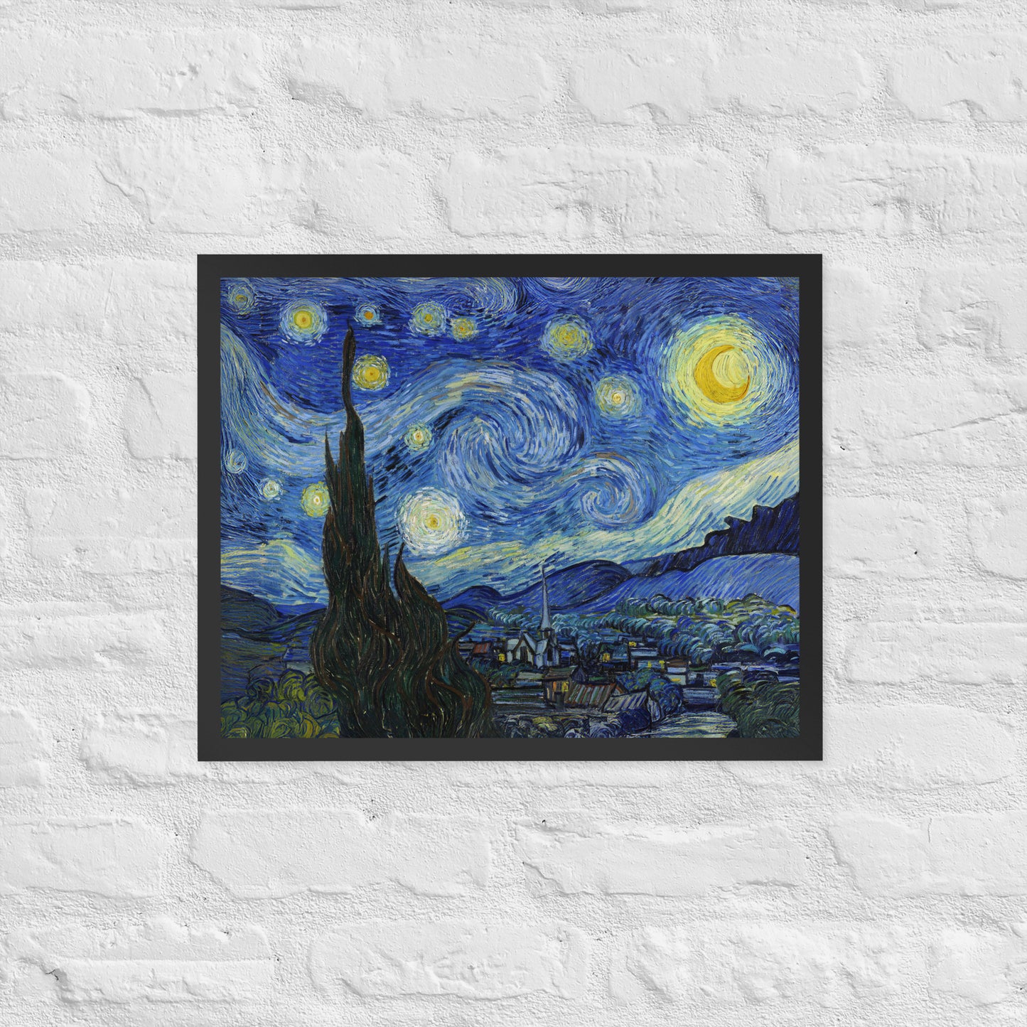 Van Gogh's 'Starry Night' on a 16"x20" black framed poster print on a white brick wall.
