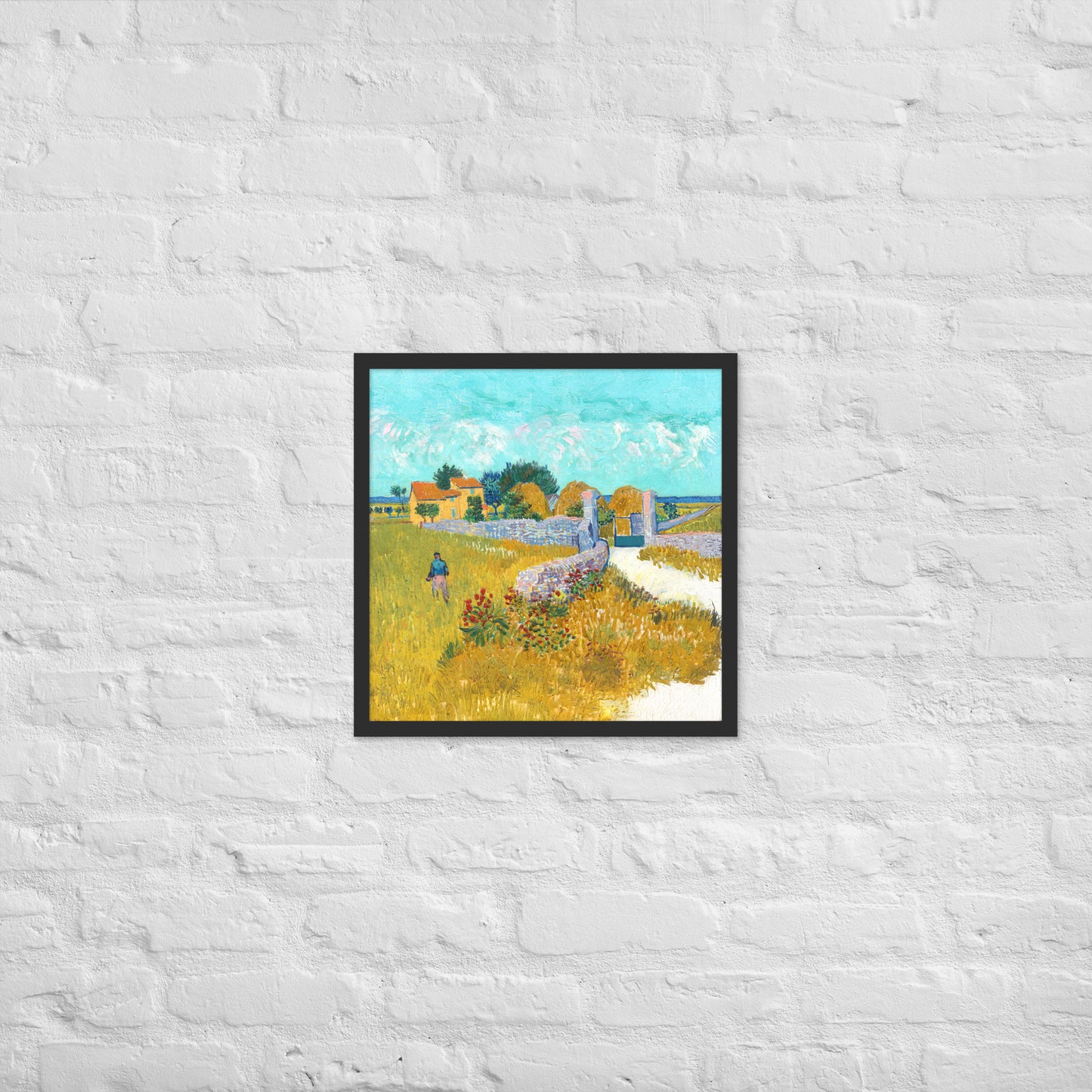 Van Gogh's 'Farmhouse in Provence' on a 18"x18" black framed poster print on a white brick wall.