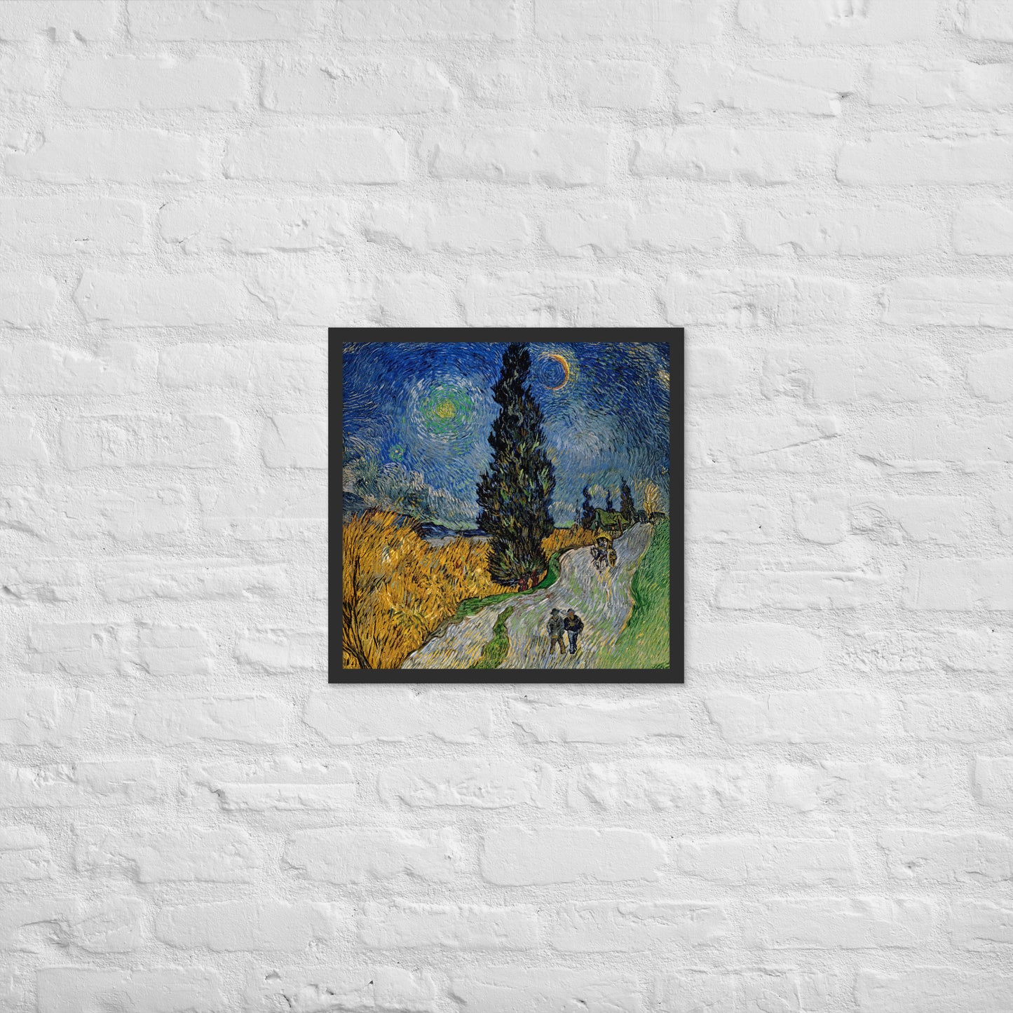 Van Gogh's 'Road with Cypress and Star' on a 18"x18" black framed poster print on a white brick wall.