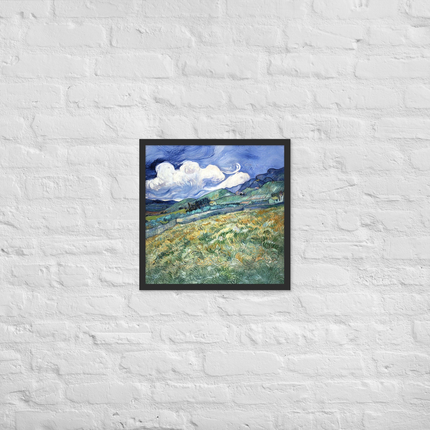 Van Gogh's 'Landscape from Saint-Rémy' on a 18"x18" black framed poster print on a white brick wall.