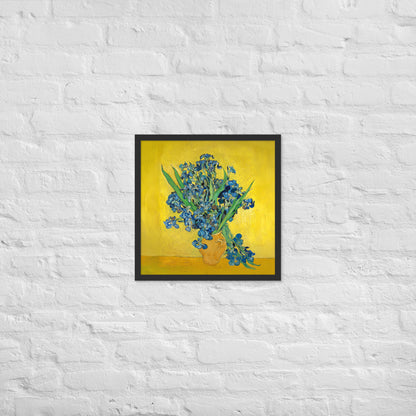 Van Gogh's 'Vase with Irises Against a Yellow Background' on a 18"x18" black framed poster print on a white brick wall.