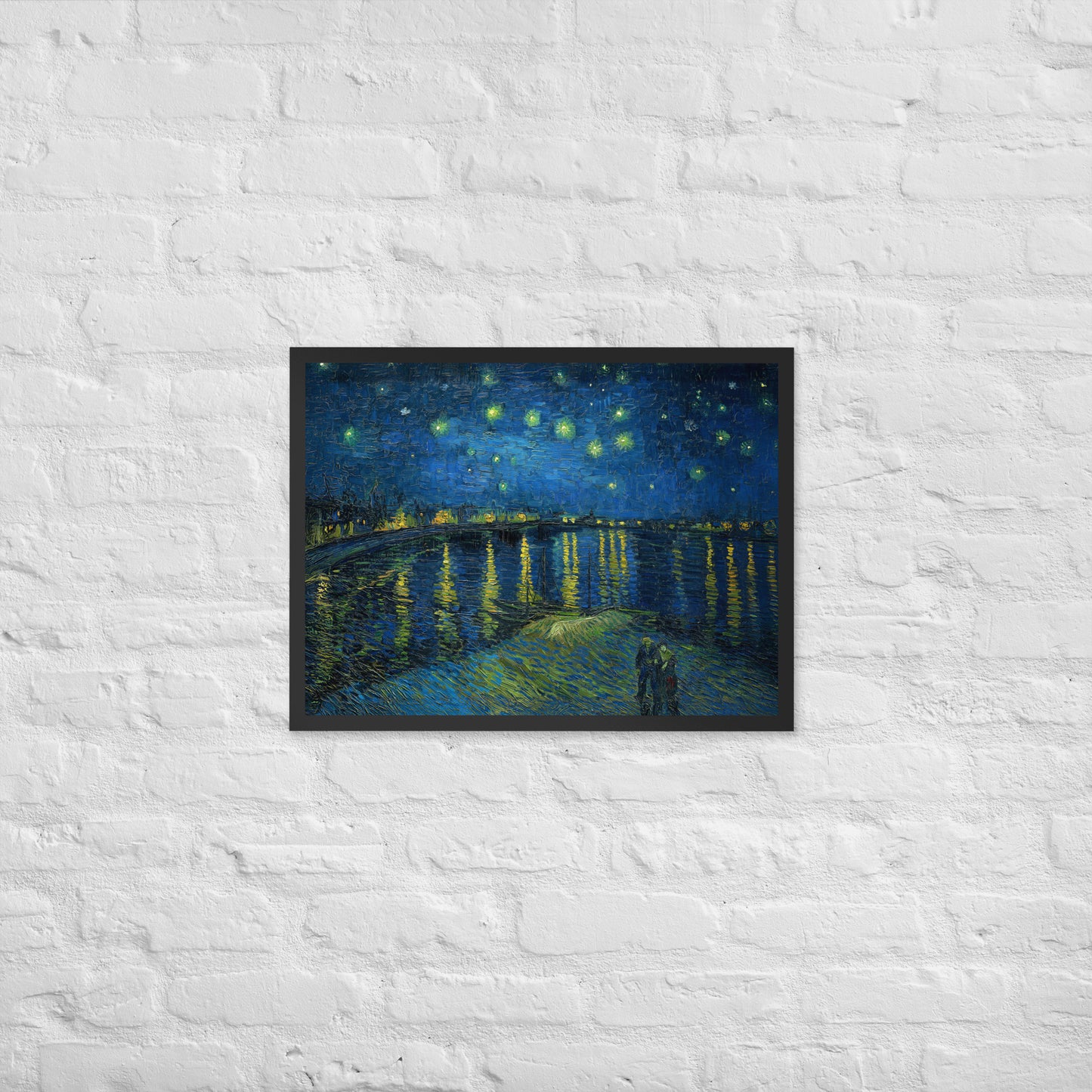 Van Gogh's 'Starry Night Over the Rhone' on a 18"x24" black framed poster print on a white brick wall.