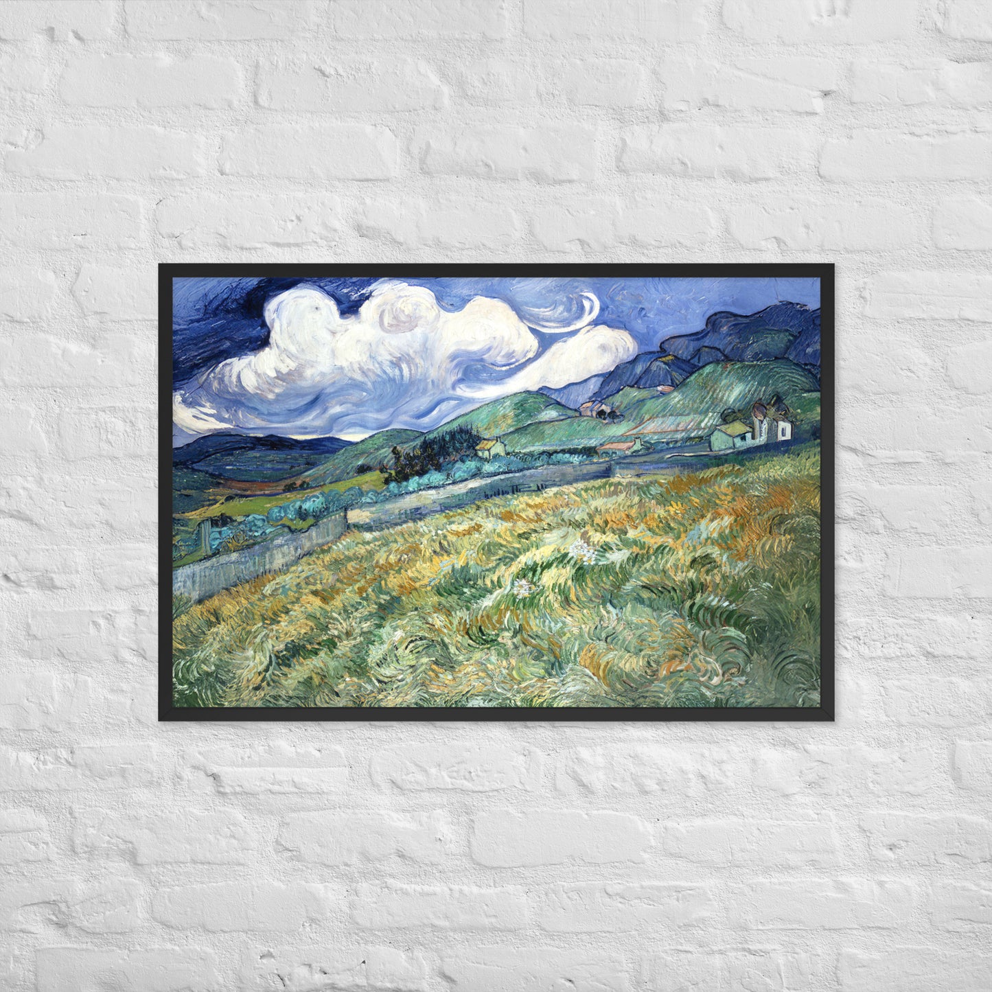 Van Gogh's 'Landscape from Saint-Rémy' on a 24"x36" black framed poster print on a white brick wall.