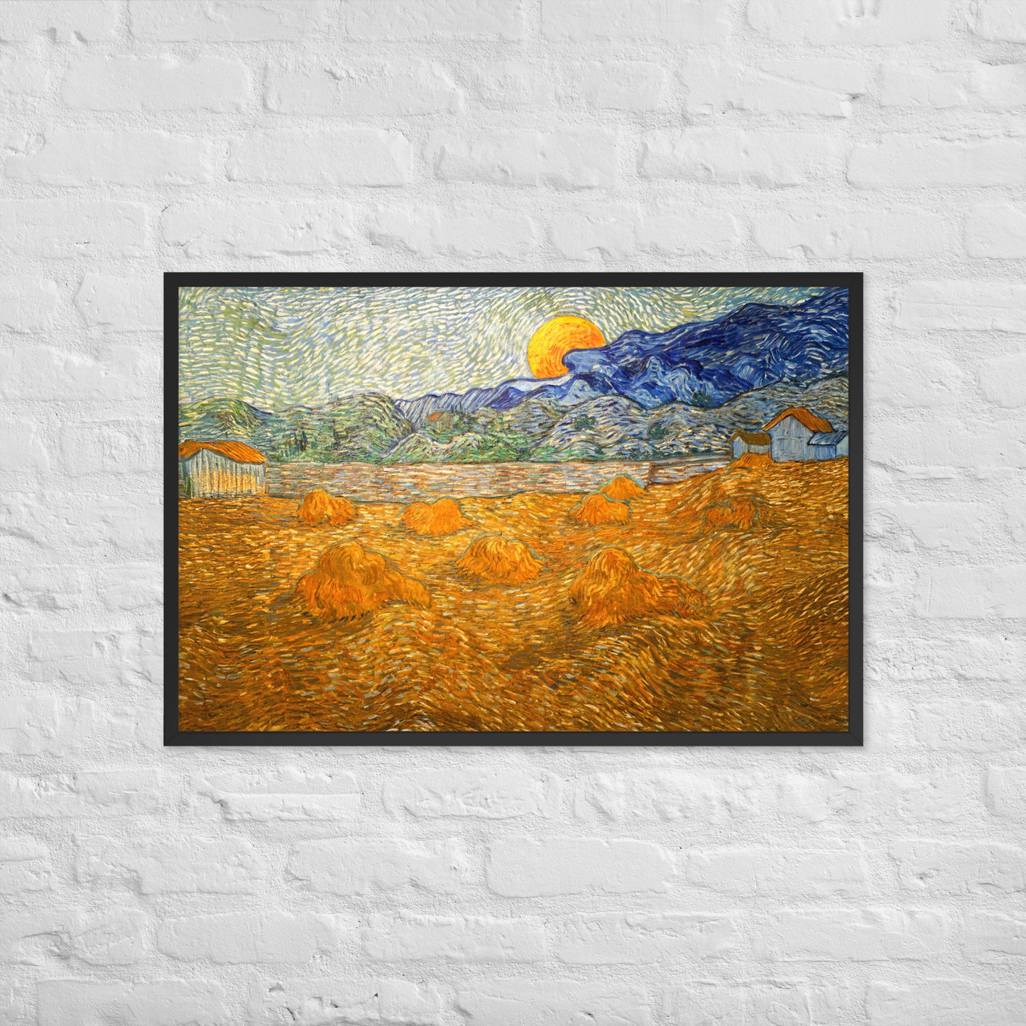 Van Gogh's 'Landscape with Wheat Sheaves and Rising Moon' on a 24"x36" black framed poster print on a white brick wall.