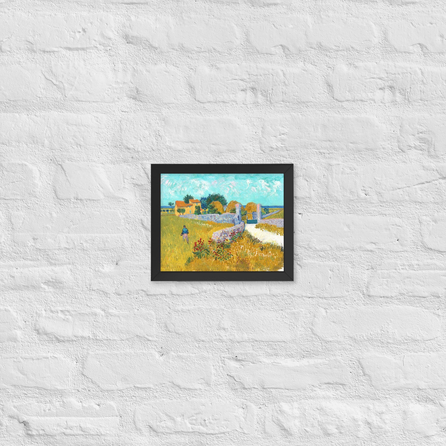 Van Gogh's 'Farmhouse in Provence' on a 8"x10" black framed poster print on a white brick wall.
