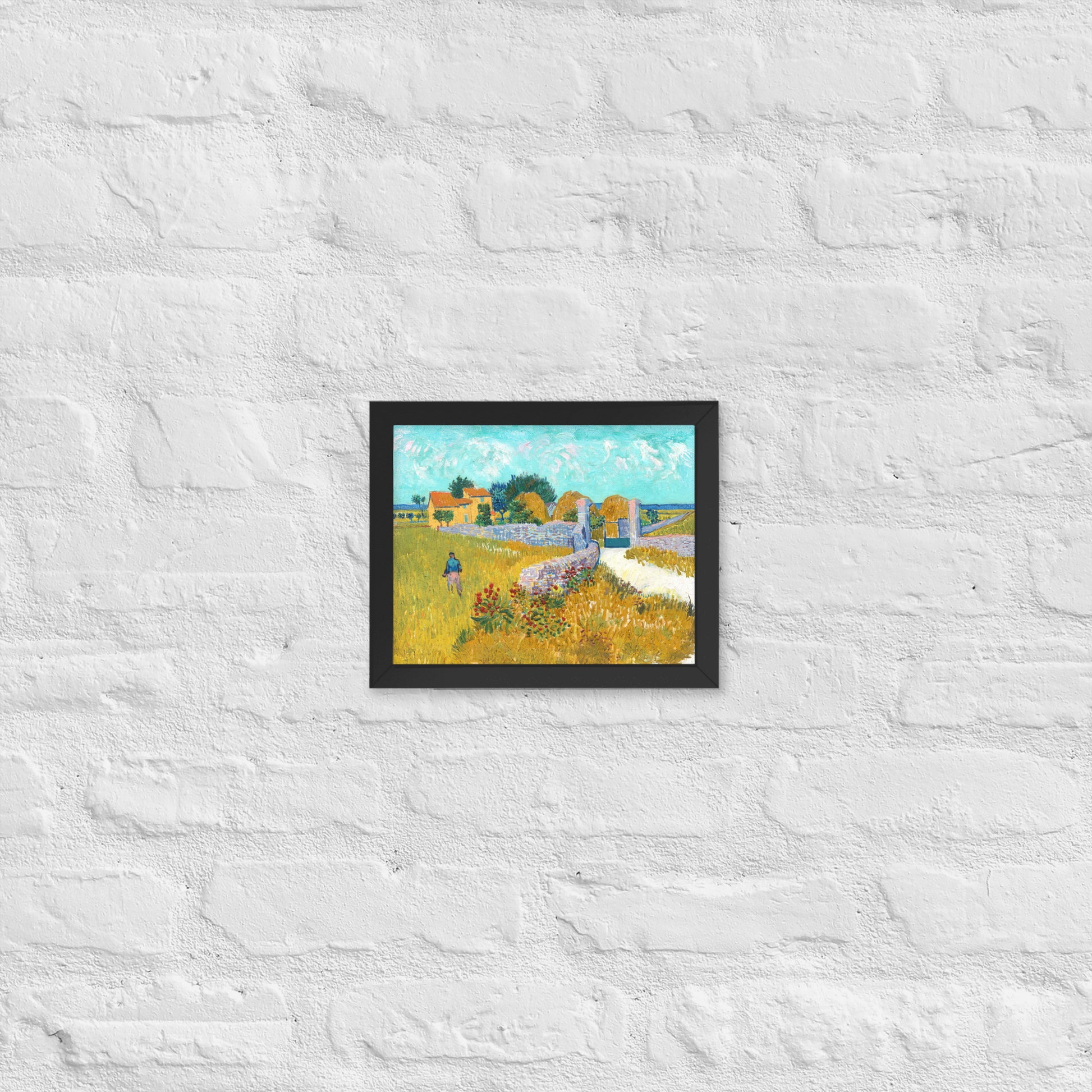 Van Gogh's 'Farmhouse in Provence' on a 8"x10" black framed poster print on a white brick wall.