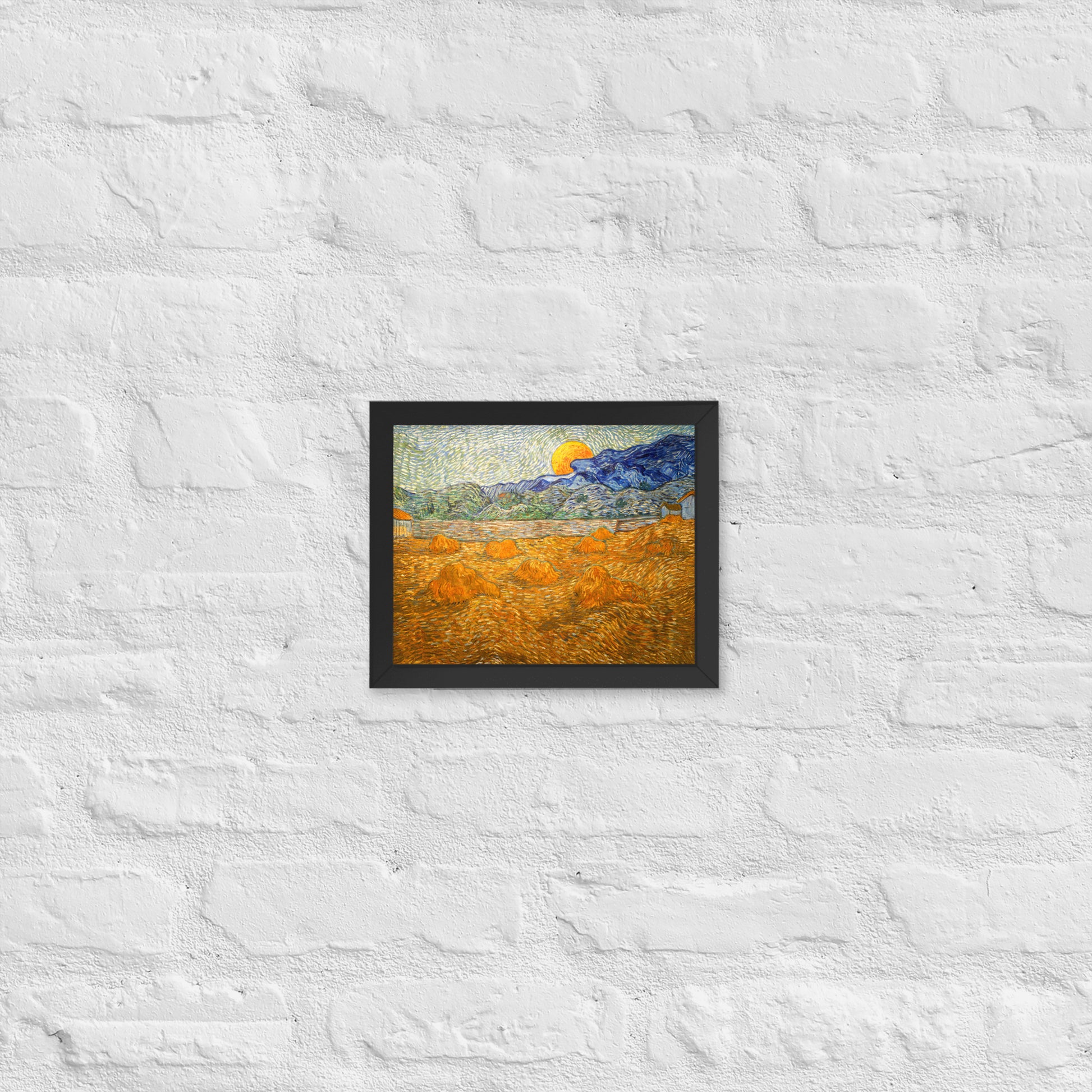 Van Gogh's 'Landscape with Wheat Sheaves and Rising Moon' on a 8"x10" black framed poster print on a white brick wall.