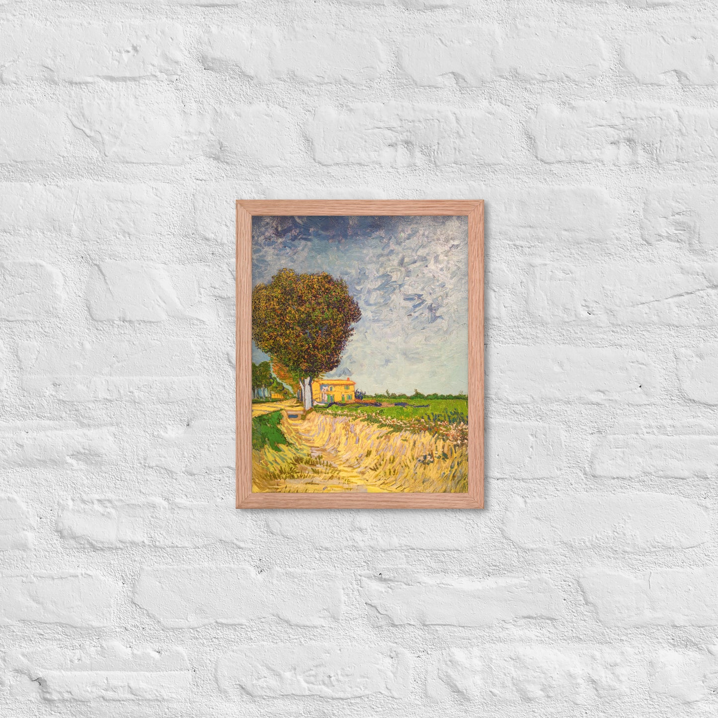 Van Gogh's 'A Lane near Arles' on a 11"x14" red oak framed poster print on a white brick wall.