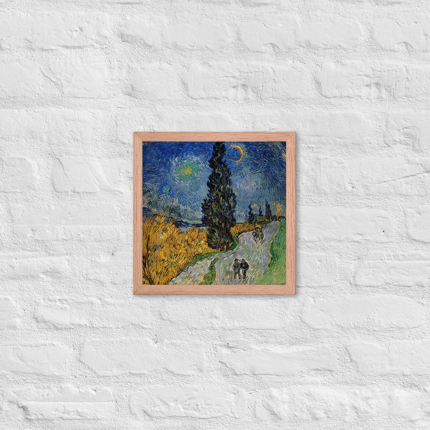 Van Gogh's 'Road with Cypress and Star' on a 12"x12" red oak framed poster print on a white brick wall.