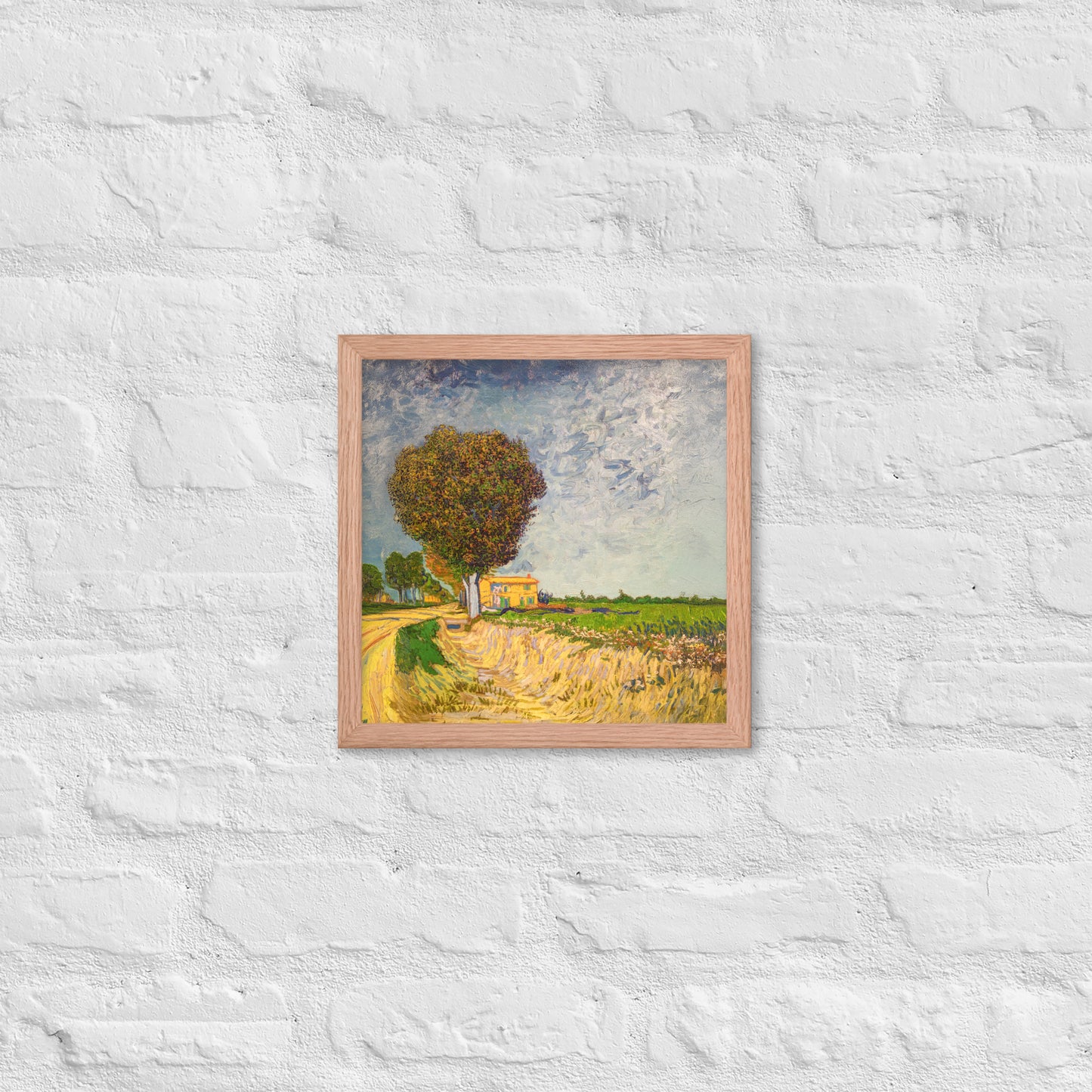 Van Gogh's 'A Lane near Arles' on a 12"x12" red oak framed poster print on a white brick wall.