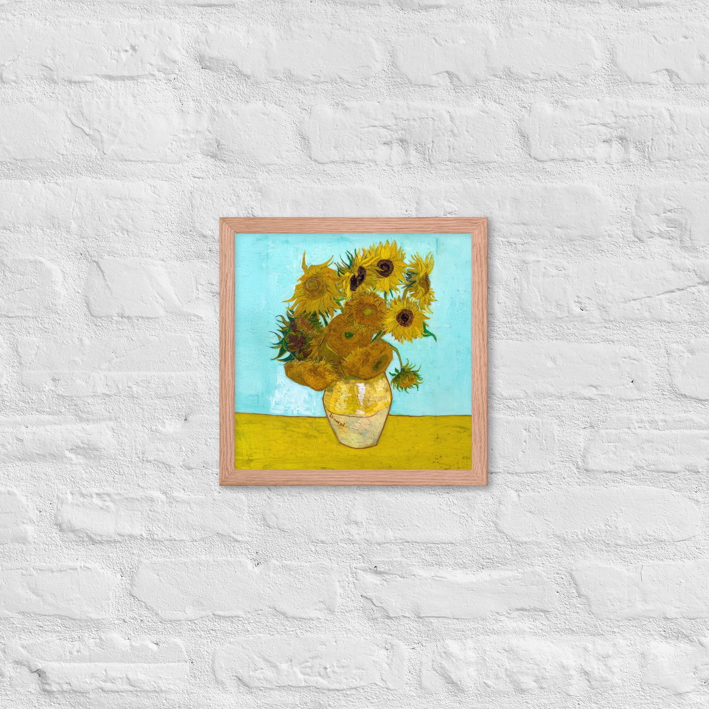 Van Gogh's 'Vase with Twelve Sunflowers' on a 12"x12" red oak framed poster print on a white brick wall.