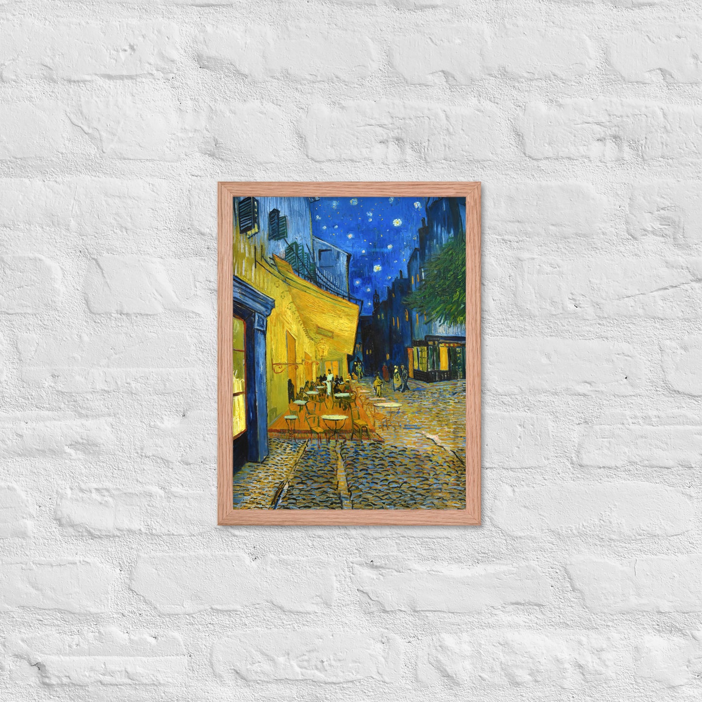 Van Gogh's 'Café Terrace at Night' on a 12"x16" red oak framed poster print on a white brick wall.