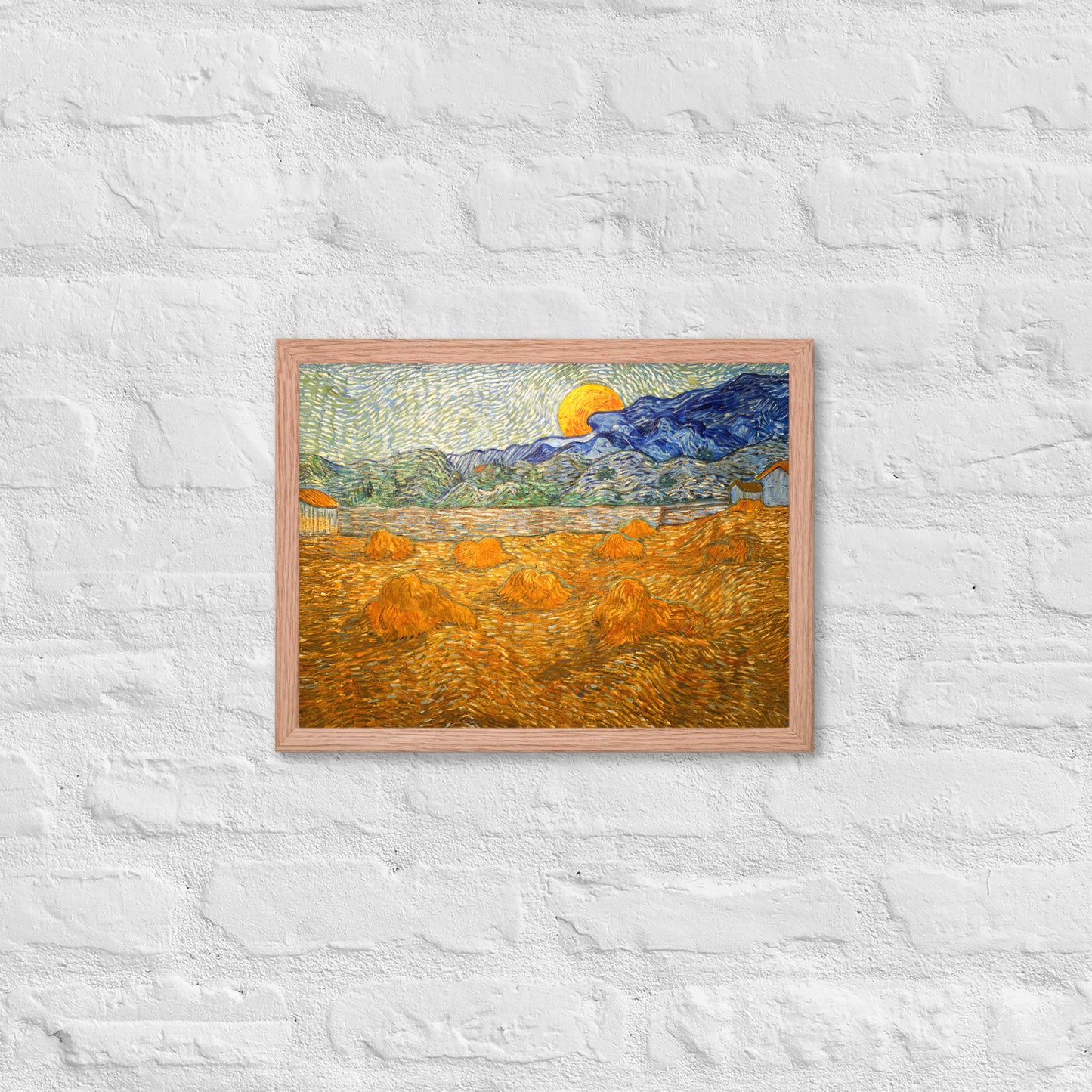 Van Gogh's 'Landscape with Wheat Sheaves and Rising Moon' on a 12"x16" red oak framed poster print on a white brick wall.