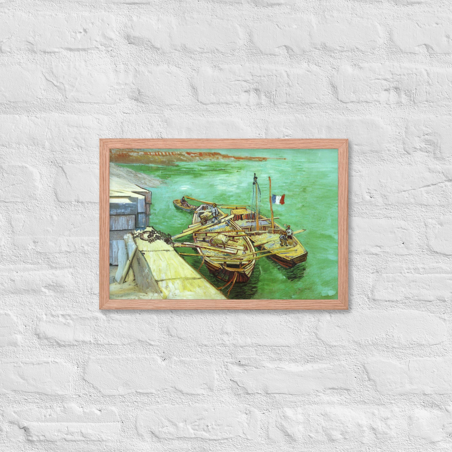 Van Gogh's 'Quay with Men Unloading Sand Barges' on a 12"x18" red oak framed poster print on a white brick wall.
