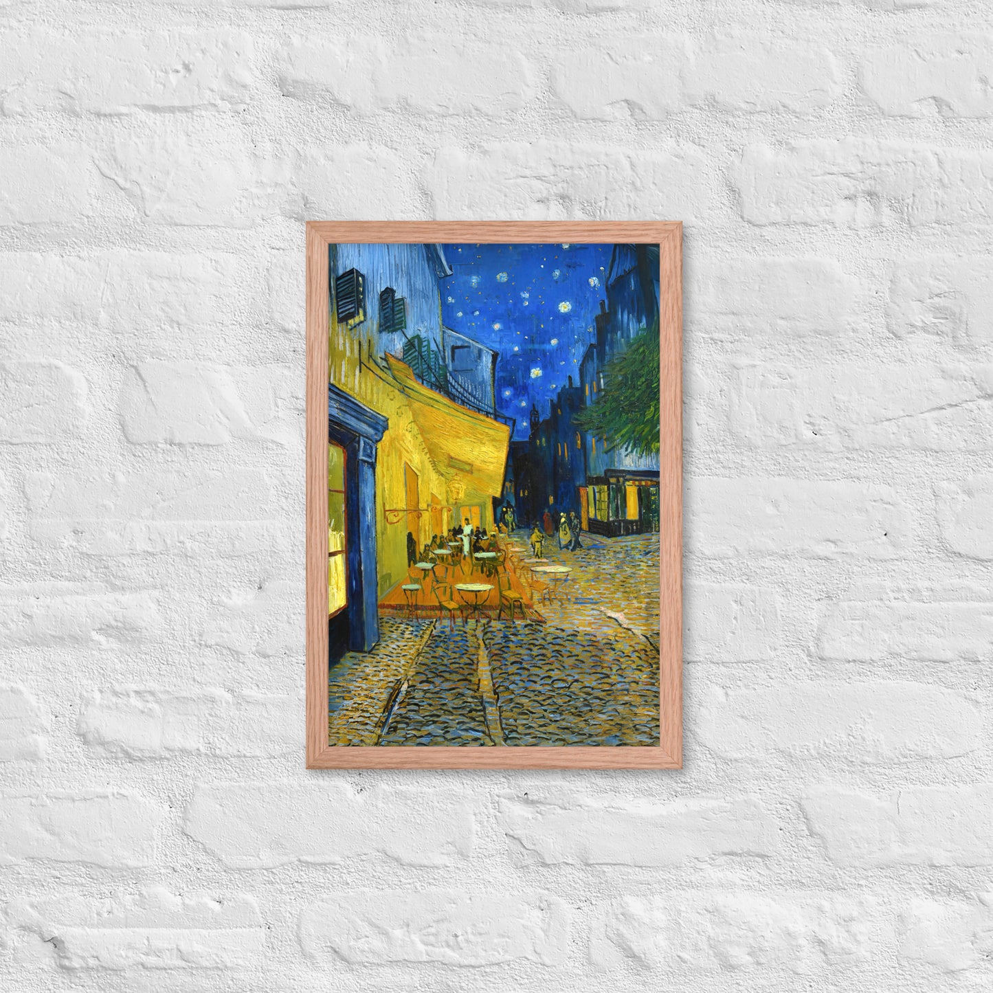 Van Gogh's 'Café Terrace at Night' on a 12"x18" red oak framed poster print on a white brick wall.