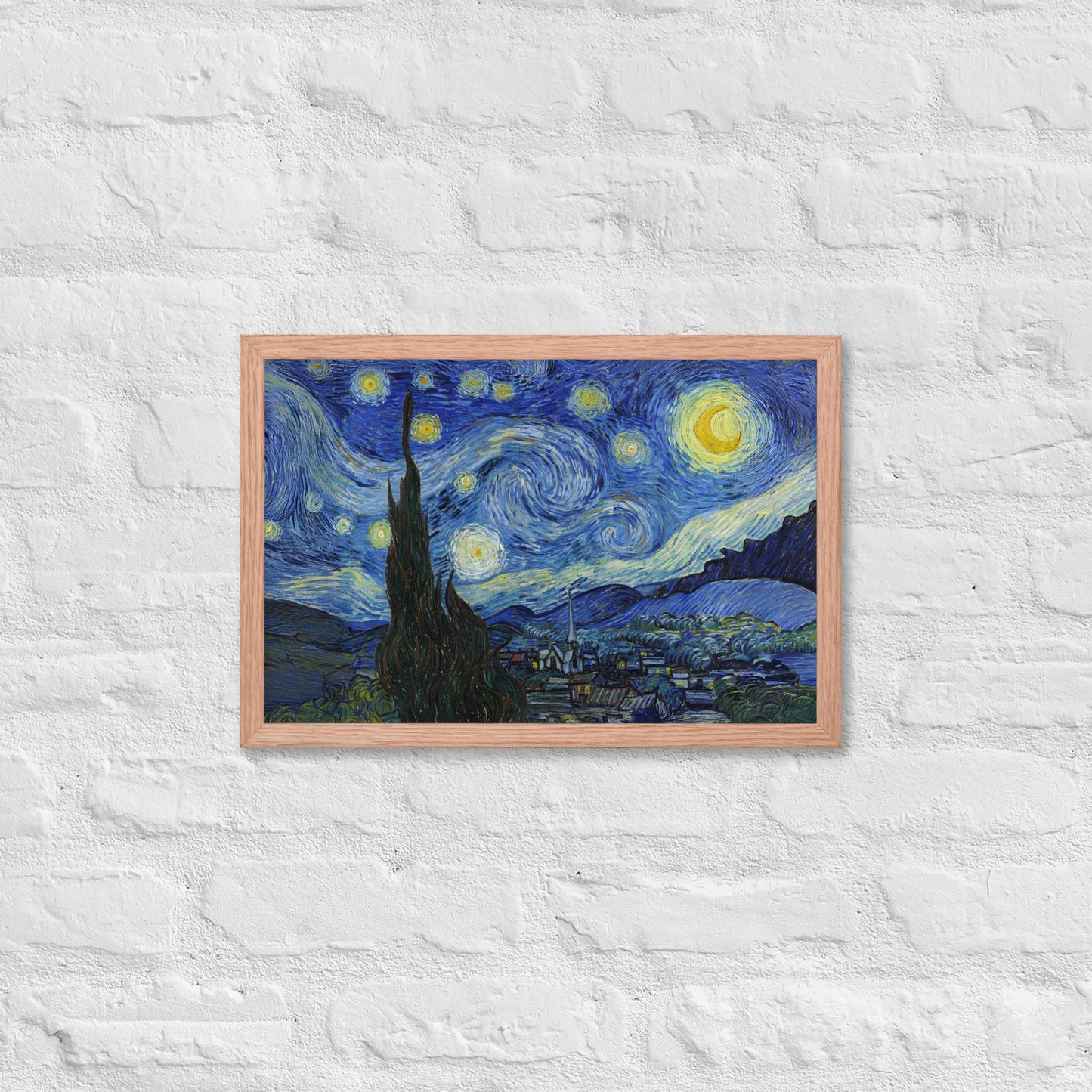 Van Gogh's 'Starry Night' on a 12"x18" red oak framed poster print on a white brick wall.