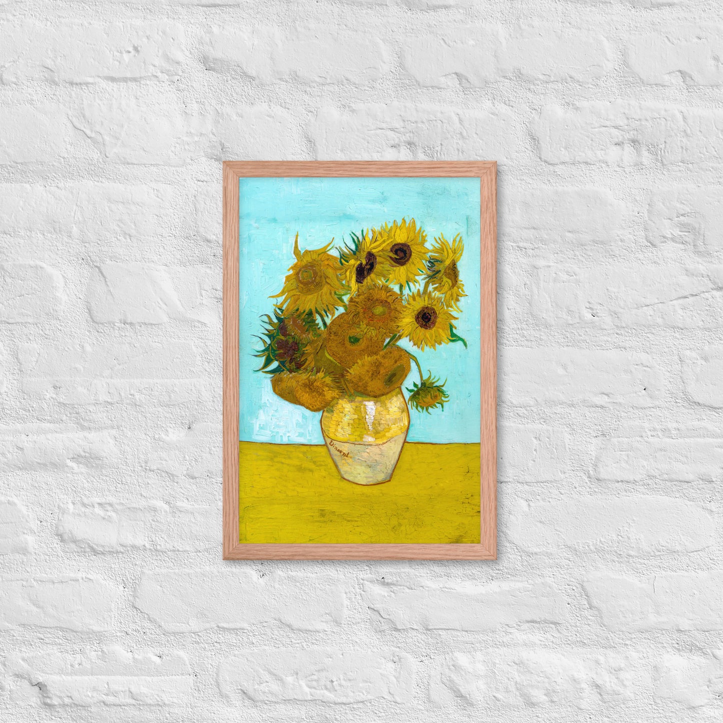 Van Gogh's 'Vase with Twelve Sunflowers' on a 12"x18" red oak framed poster print on a white brick wall.