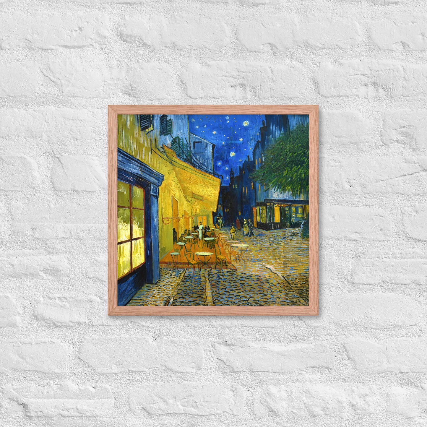 Van Gogh's 'Café Terrace at Night' on a 16"x16" red oak framed poster print on a white brick wall.