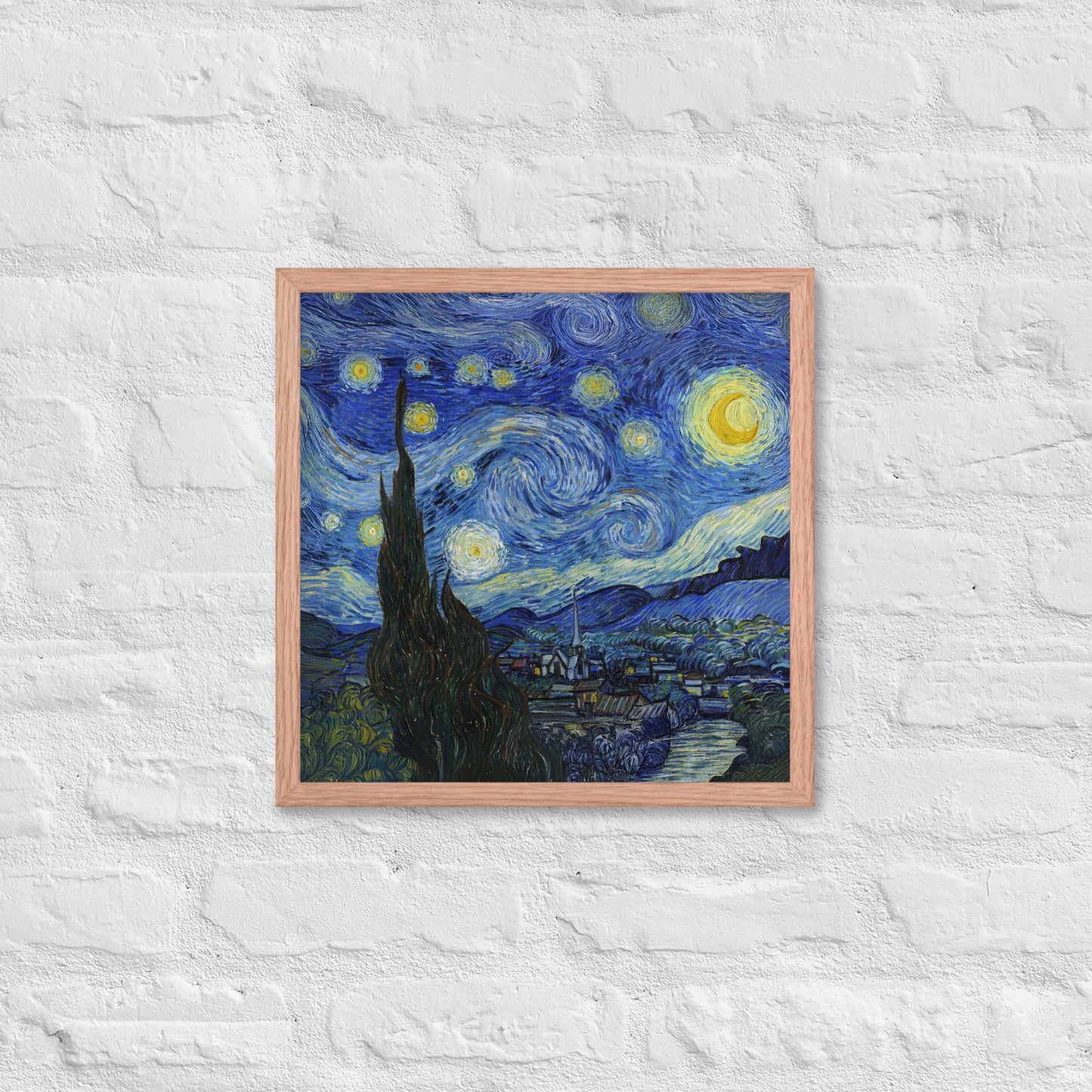 Van Gogh's 'Starry Night' on a 16"x16" red oak framed poster print on a white brick wall.
