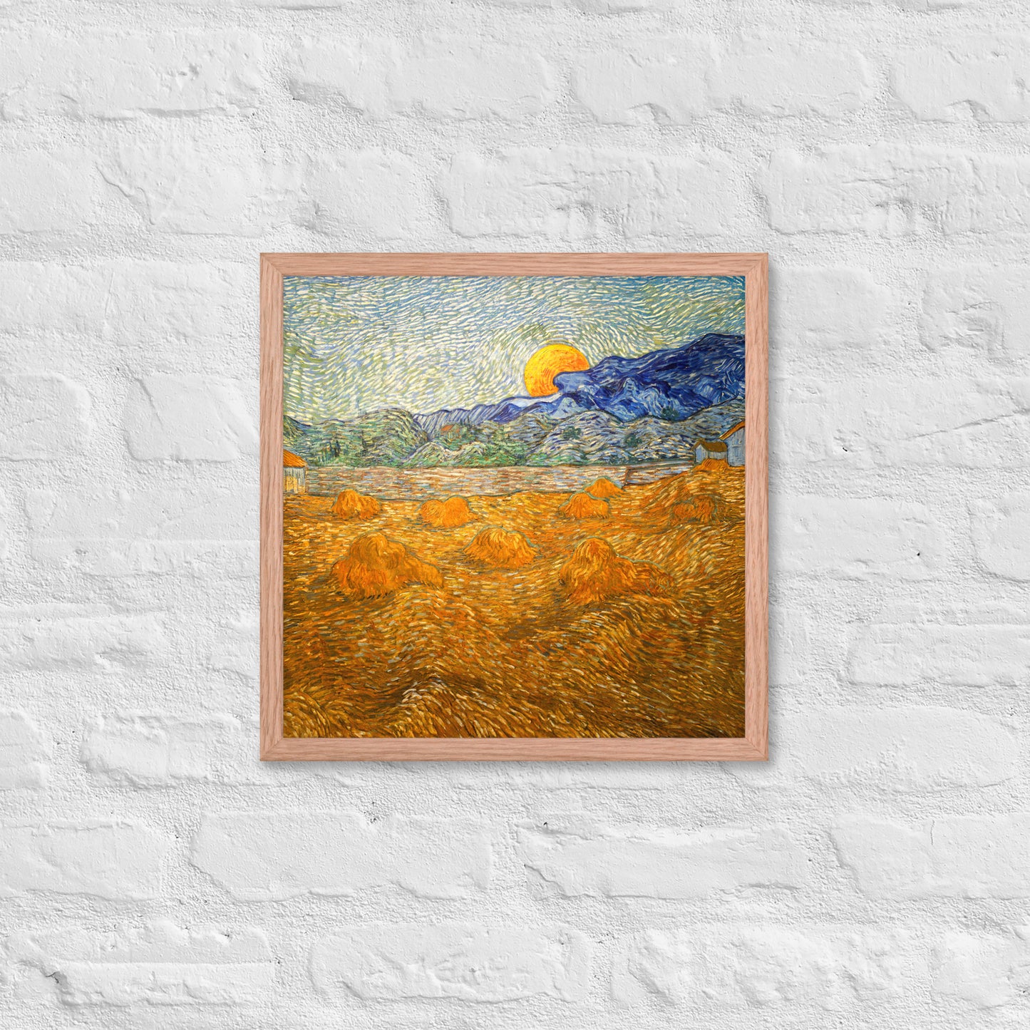Van Gogh's 'Landscape with Wheat Sheaves and Rising Moon' on a 16"x16" red oak framed poster print on a white brick wall.