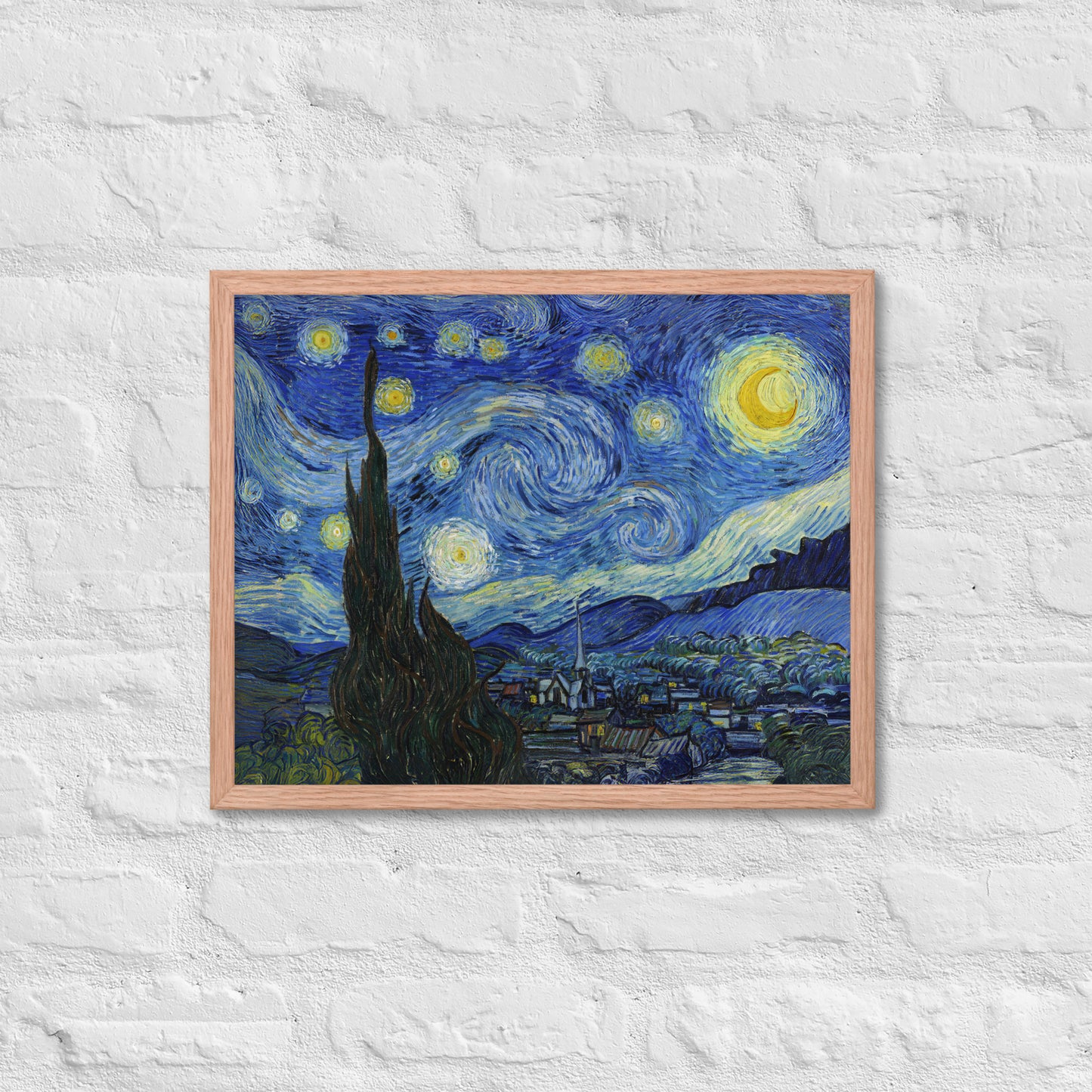 Van Gogh's 'Starry Night' on a 16"x20" red oak framed poster print on a white brick wall.