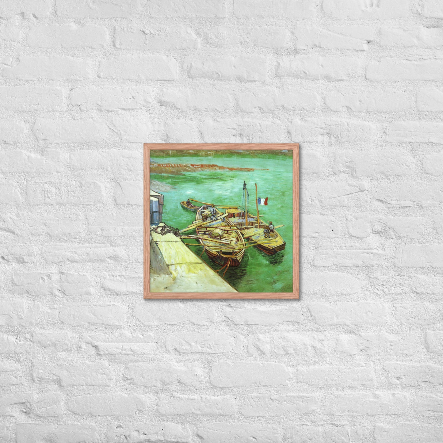 Van Gogh's 'Quay with Men Unloading Sand Barges' on a 18"x18" red oak framed poster print on a white brick wall.