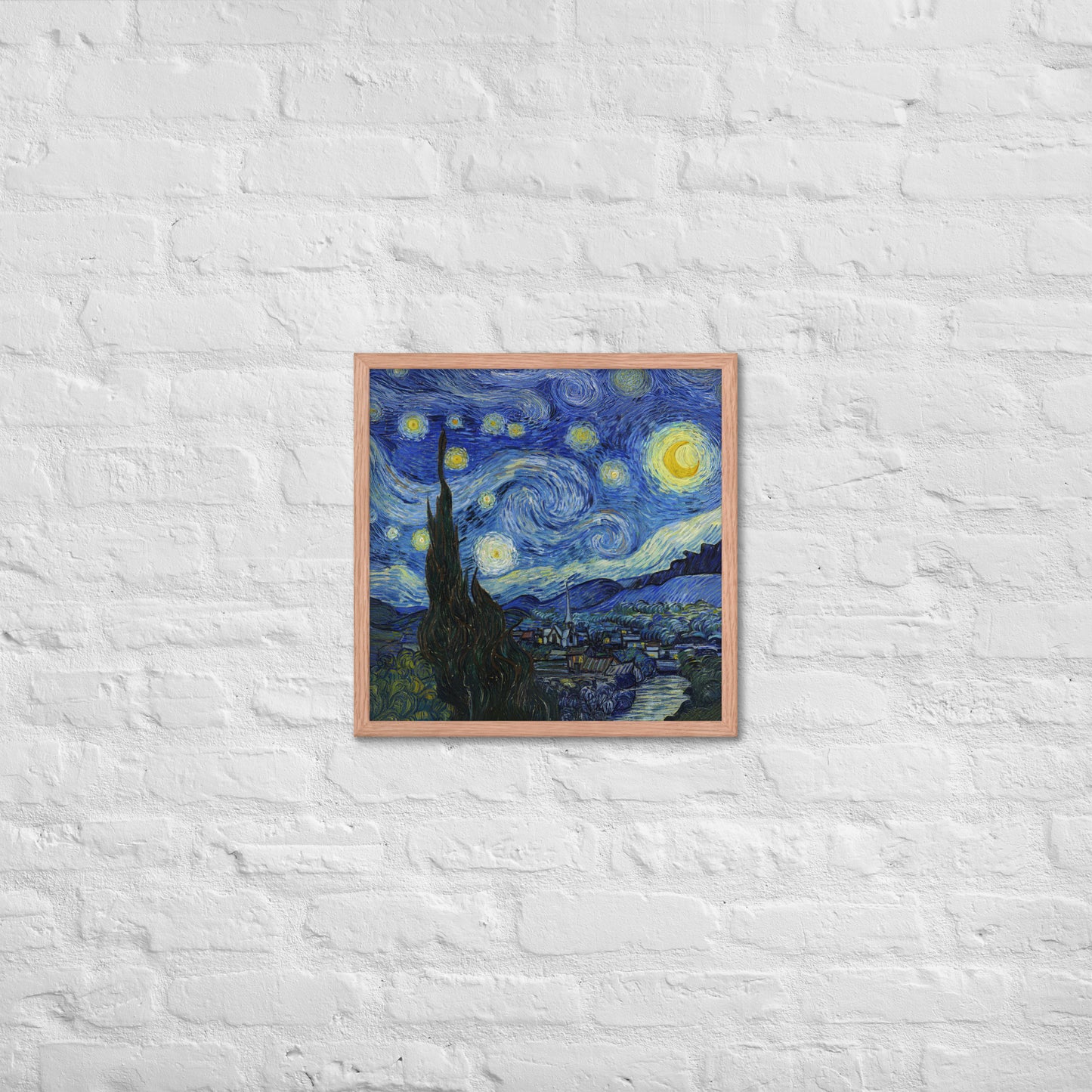 Van Gogh's 'Starry Night' on a 18"x18" red oak framed poster print on a white brick wall.