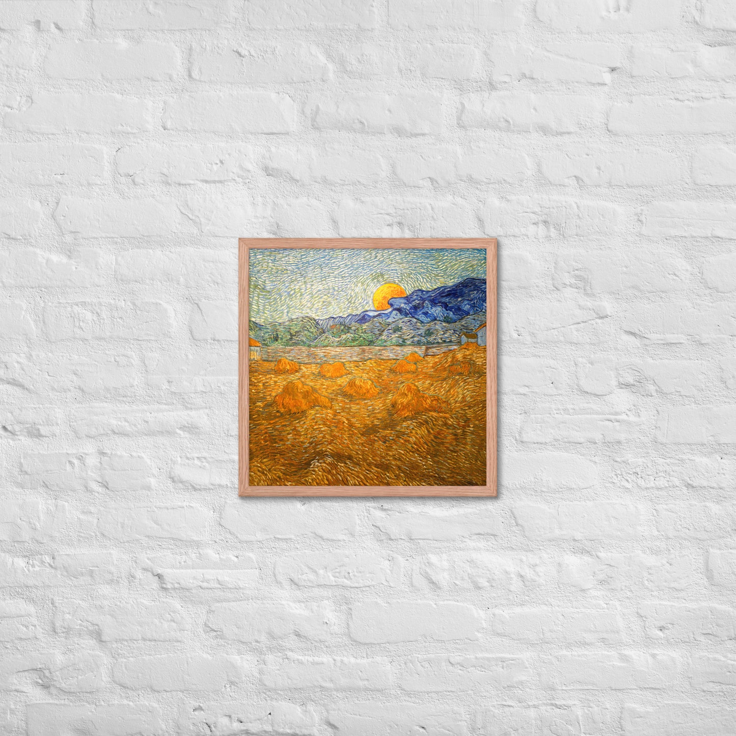 Van Gogh's 'Landscape with Wheat Sheaves and Rising Moon' on a 18"x18" red oak framed poster print on a white brick wall.