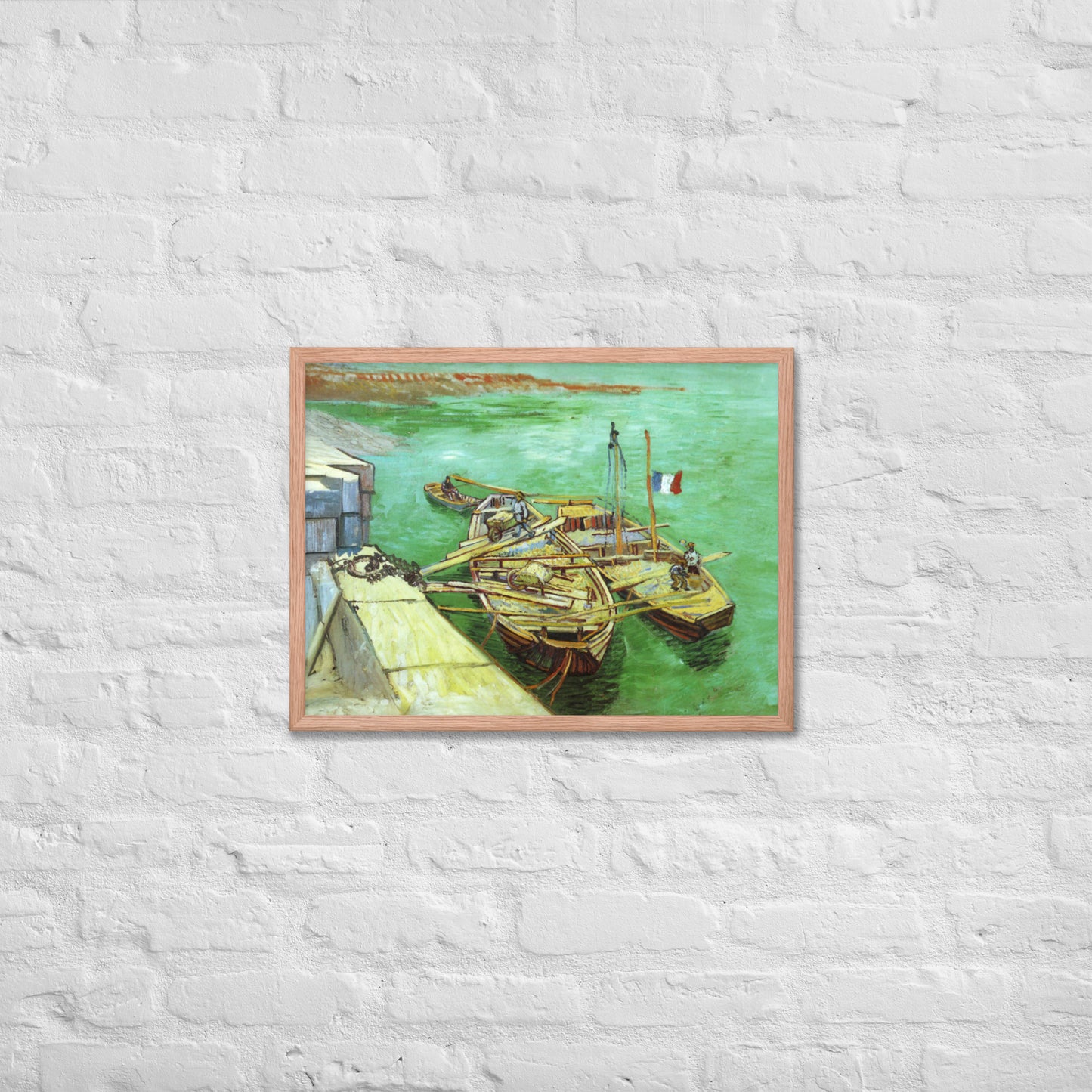 Van Gogh's 'Quay with Men Unloading Sand Barges' on a 18"x24" red oak framed poster print on a white brick wall.