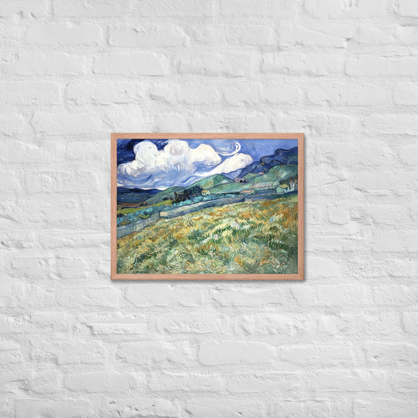 Van Gogh's 'Landscape from Saint-Rémy' on a 18"x24" red oak framed poster print on a white brick wall.