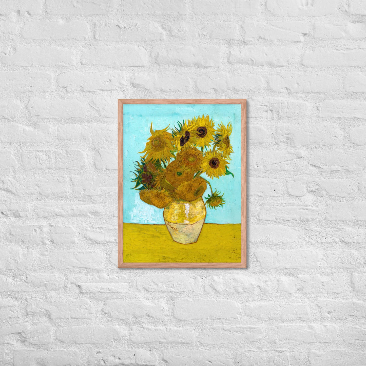 Van Gogh's 'Vase with Twelve Sunflowers' on a 18"x24" red oak framed poster print on a white brick wall.