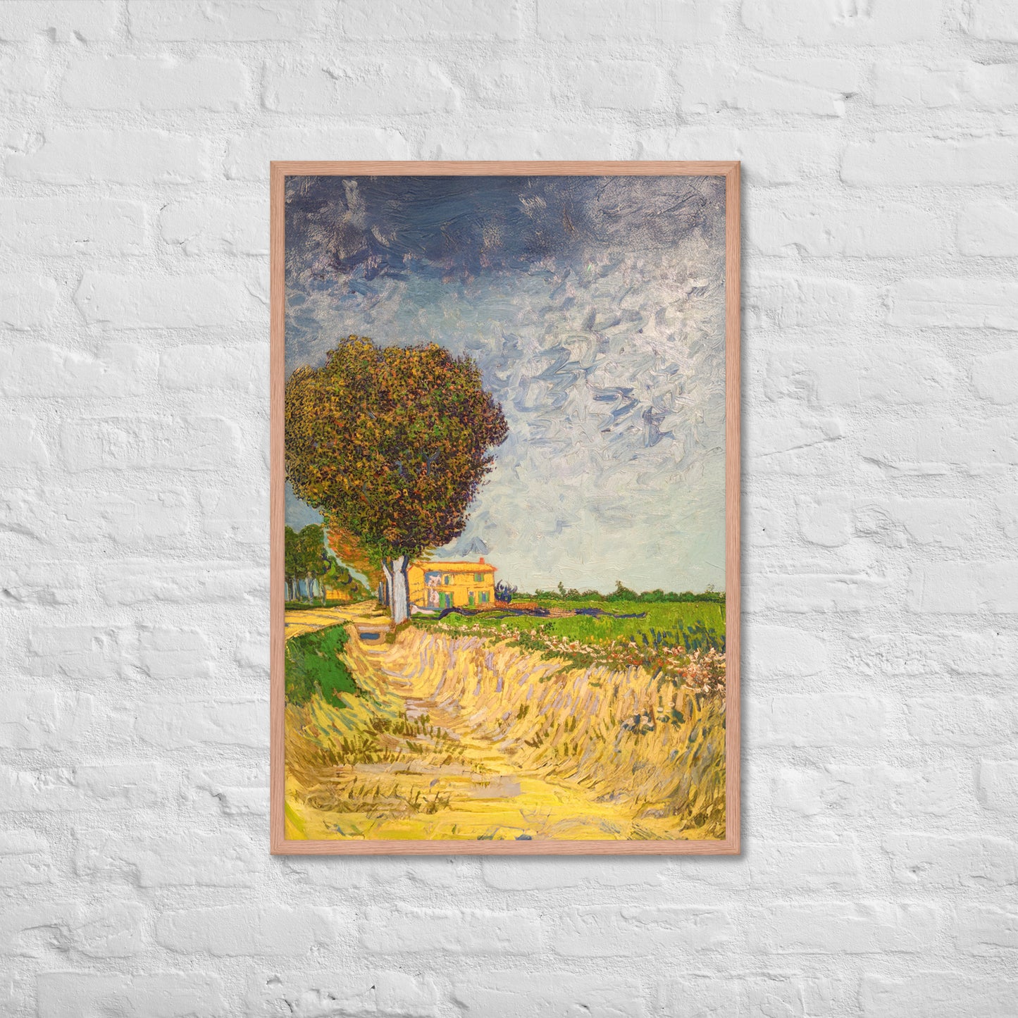 Van Gogh's 'A Lane near Arles' on a 24"x36" red oak framed poster print on a white brick wall.
