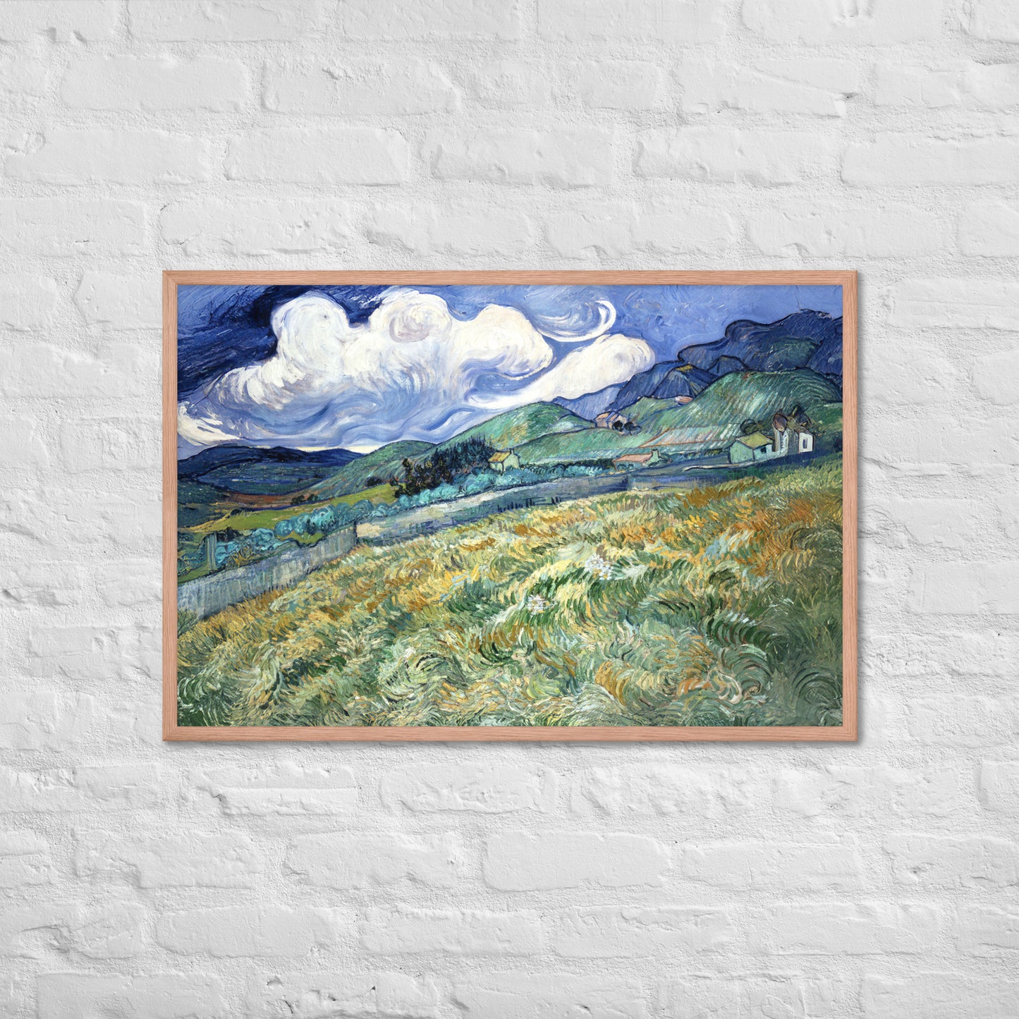 Van Gogh's 'Landscape from Saint-Rémy' on a 24"x36" red oak framed poster print on a white brick wall.