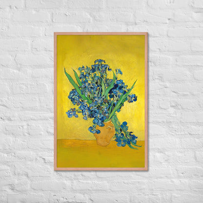 Van Gogh's 'Vase with Irises Against a Yellow Background' on a 24"x36" red oak framed poster print on a white brick wall.