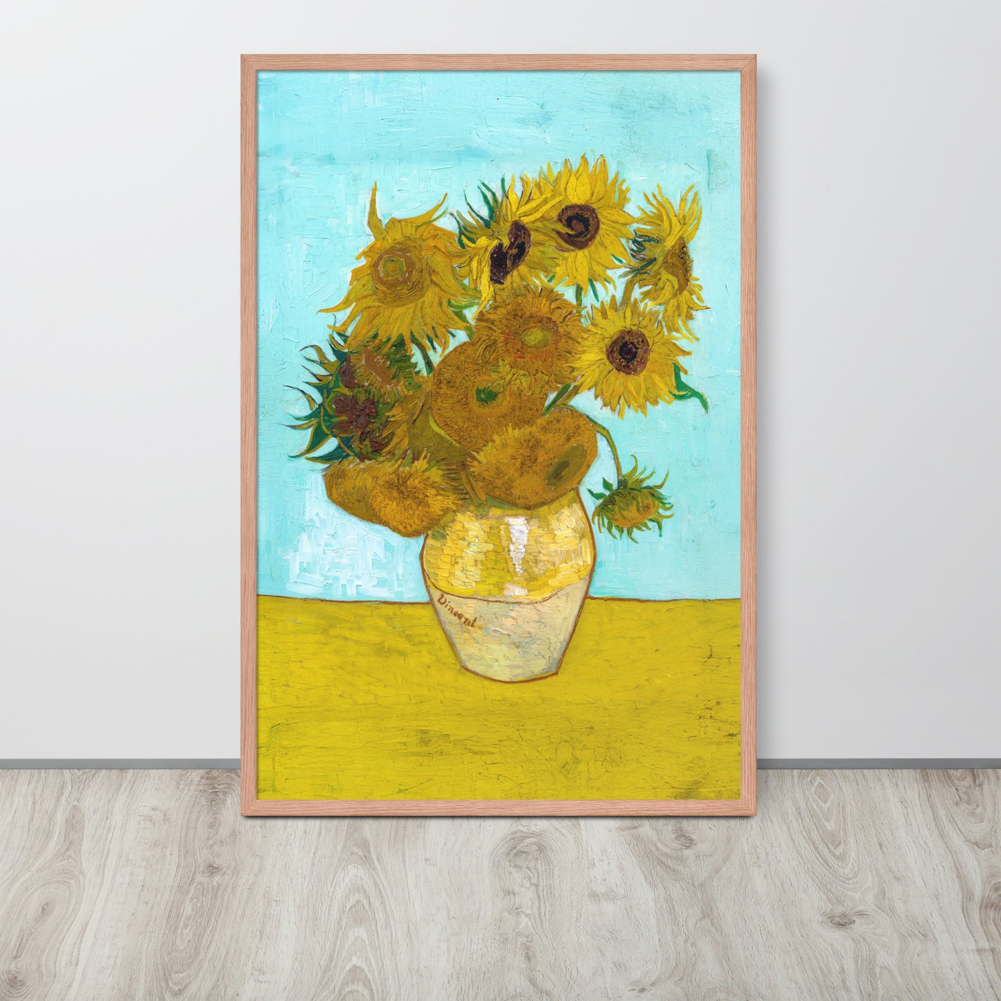 Van Gogh's 'Vase with Twelve Sunflowers' on a 24"x36" red oak framed poster print sitting on a wooden floor leaning against a light gray wall.