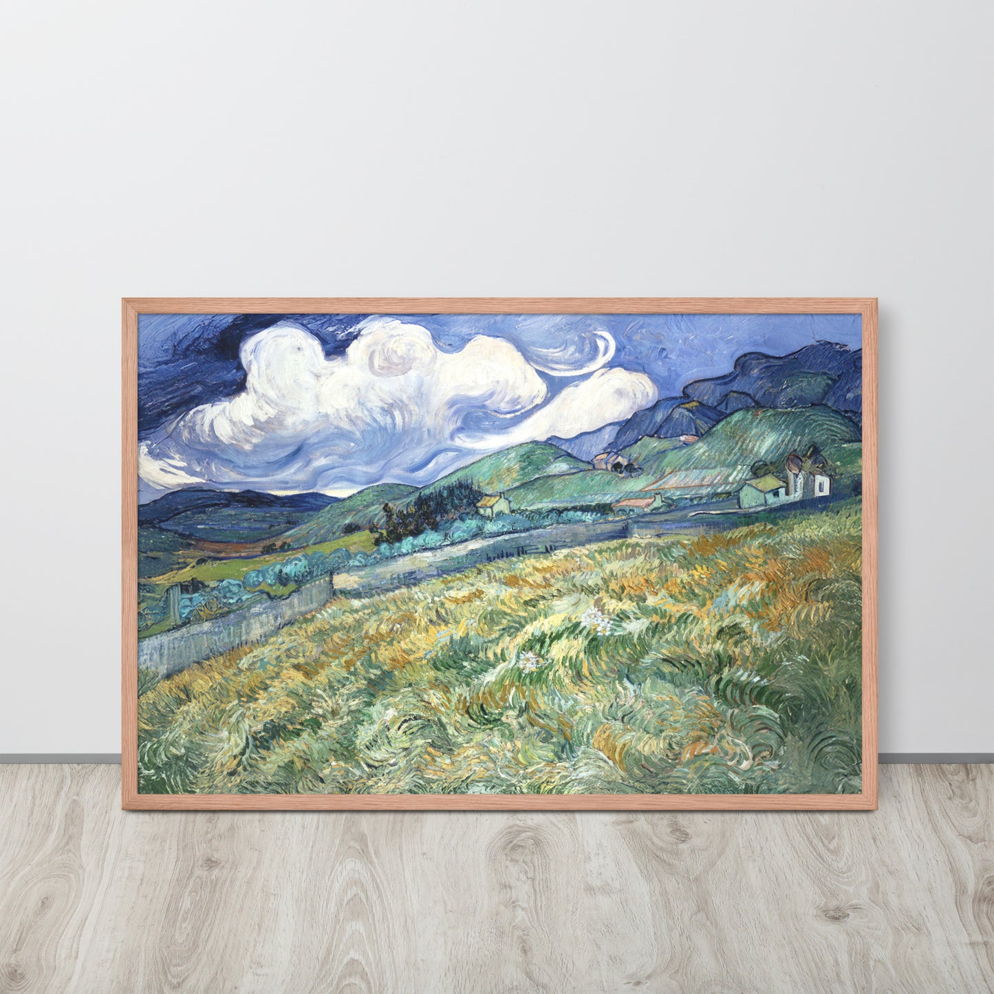 Van Gogh's 'Landscape from Saint-Rémy' on a 24"x36" red oak framed poster print sitting on a wooden floor leaning against a light gray wall.