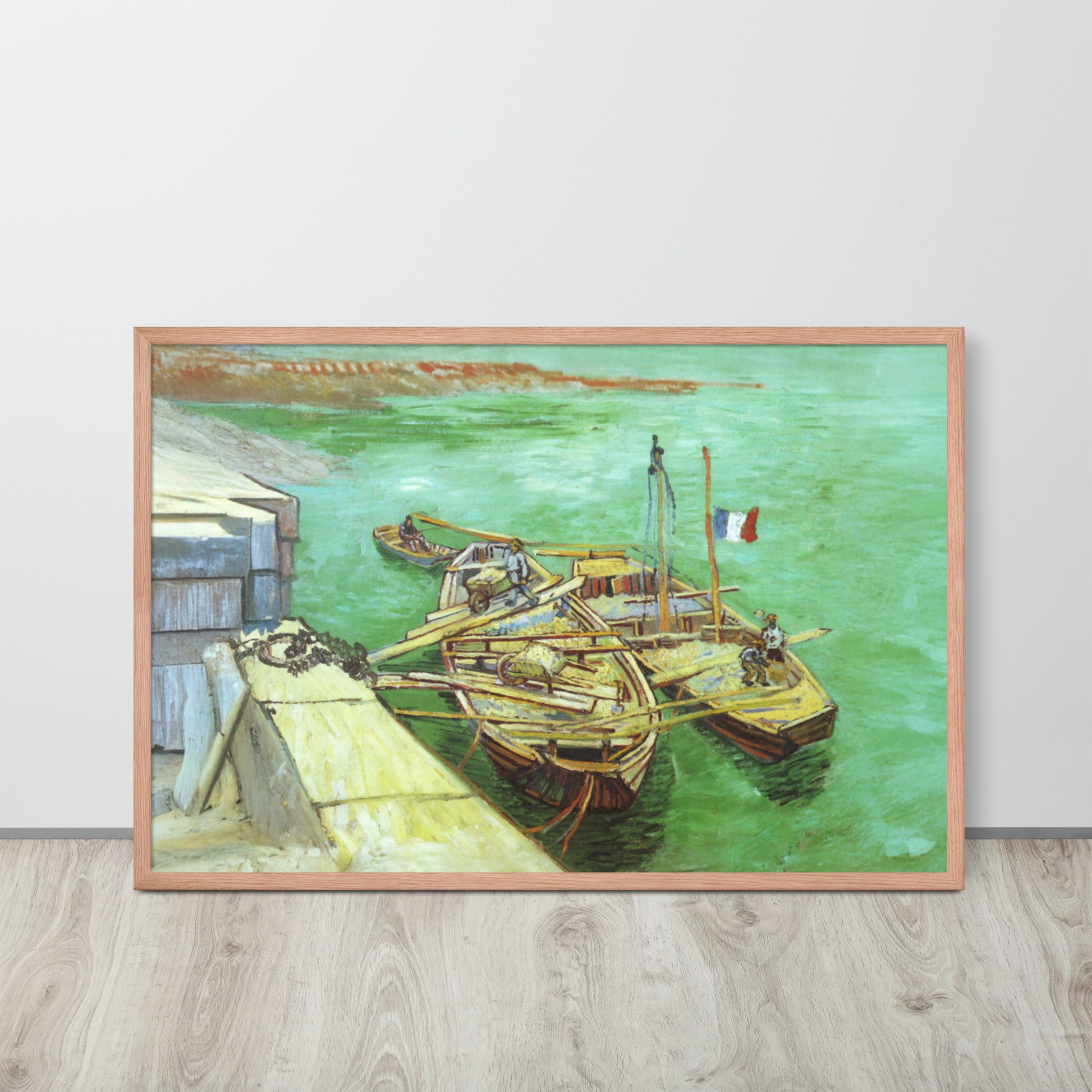 Van Gogh's 'Quay with Men Unloading Sand Barges' on a 24"x36" red oak framed poster print sitting on a wooden floor leaning against a light gray wall.