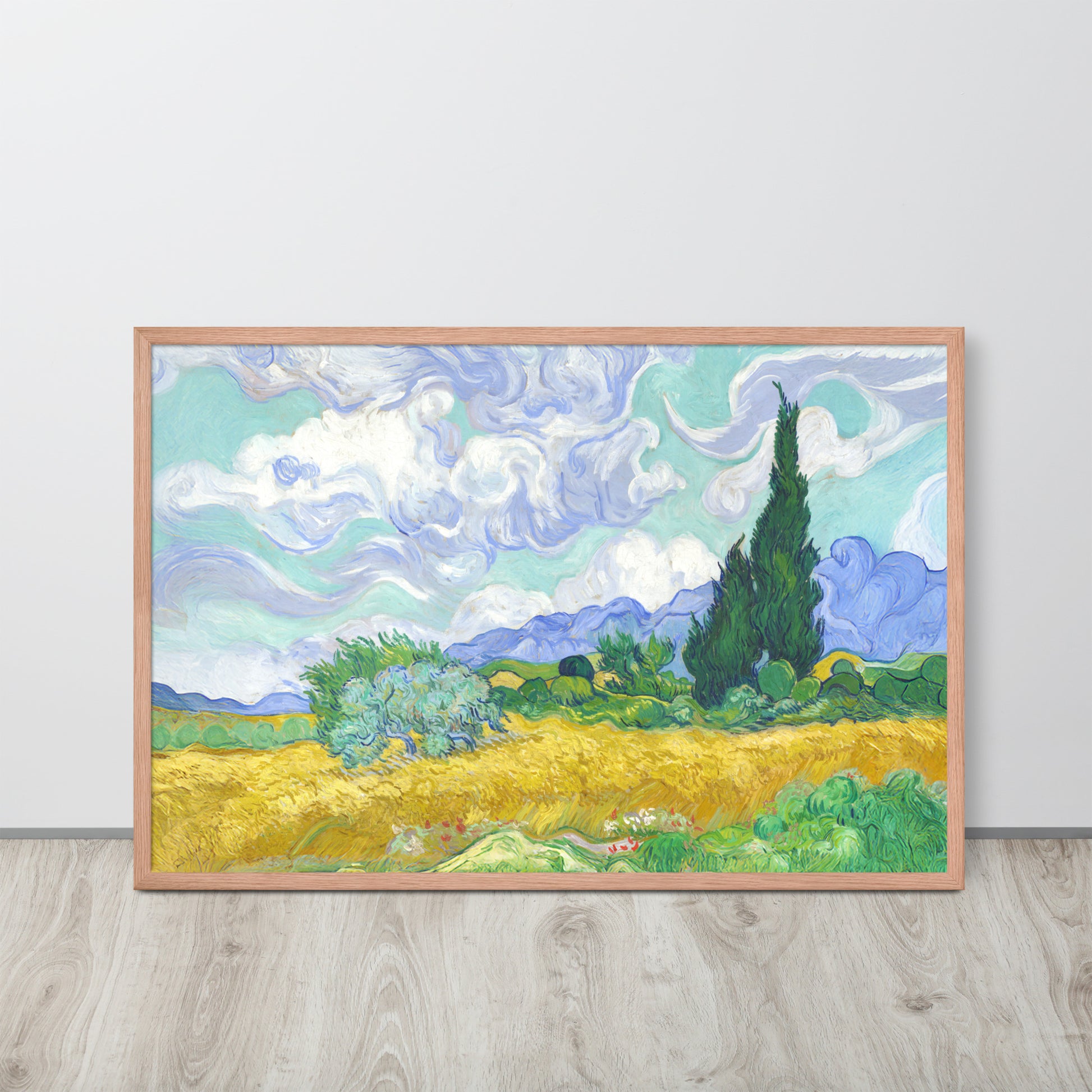 Van Gogh's 'Wheat Field with Cypresses' on a 24"x36" red oak framed poster print sitting on a wooden floor leaning against a light gray wall.