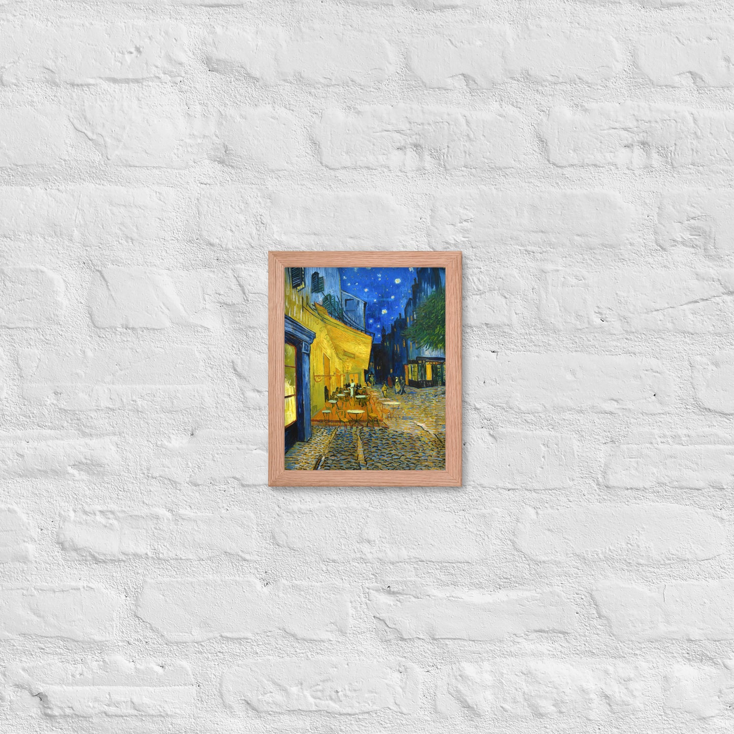 Van Gogh's 'Café Terrace at Night' on a 8"x10" red oak framed poster print on a white brick wall.
