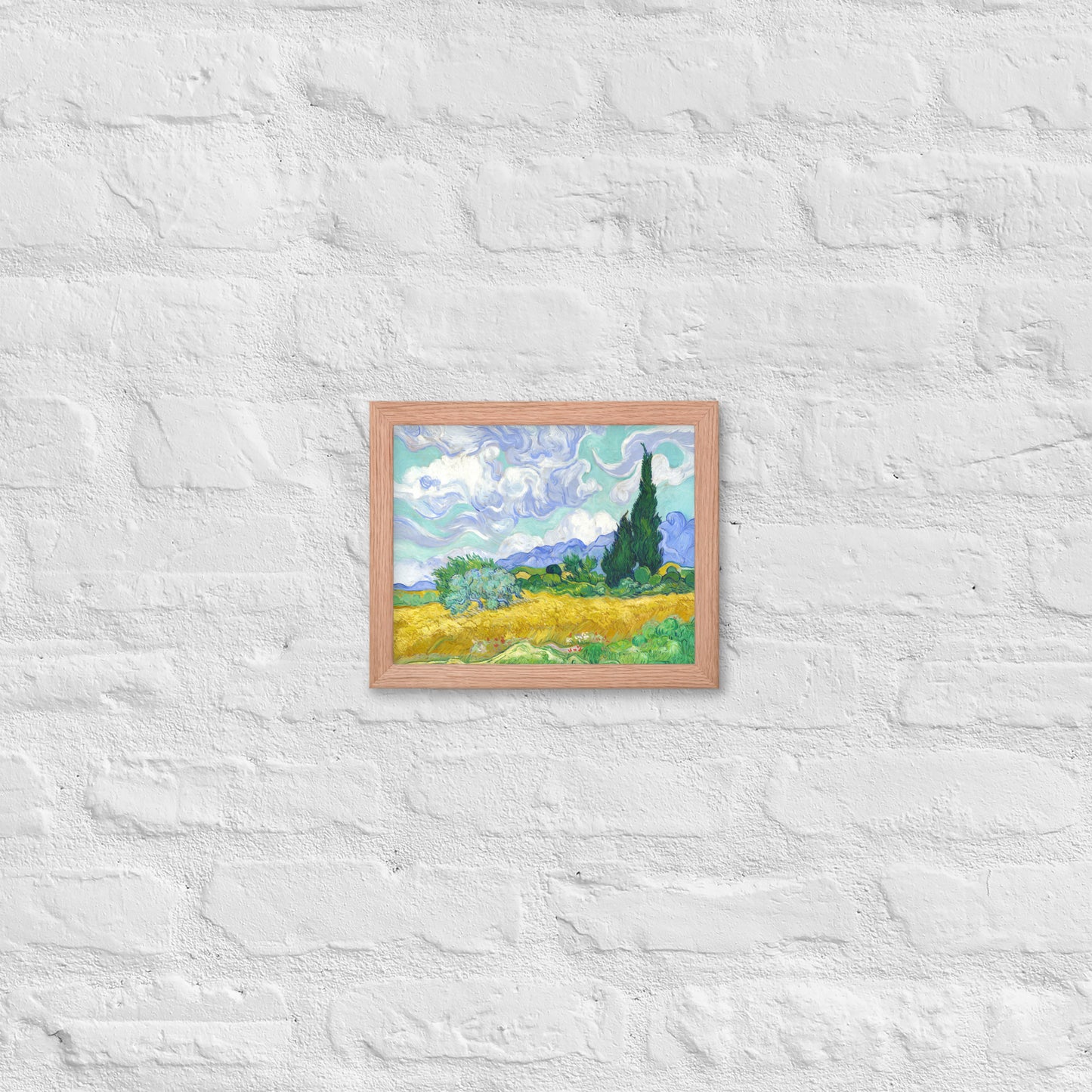 Van Gogh's 'Wheat Field with Cypresses' on a 8"x10" red oak framed poster print on a white brick wall.