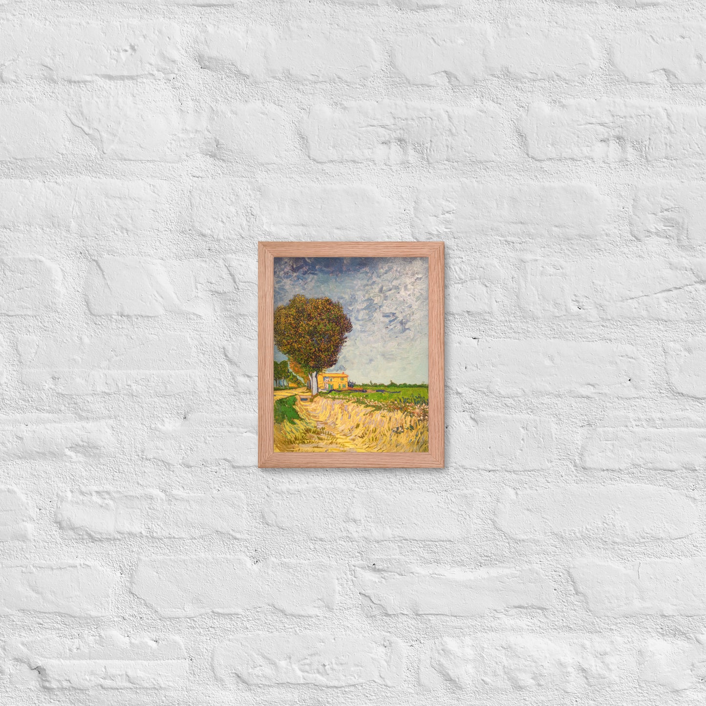 Van Gogh's 'A Lane near Arles' on a 8"x10" red oak framed poster print on a white brick wall.