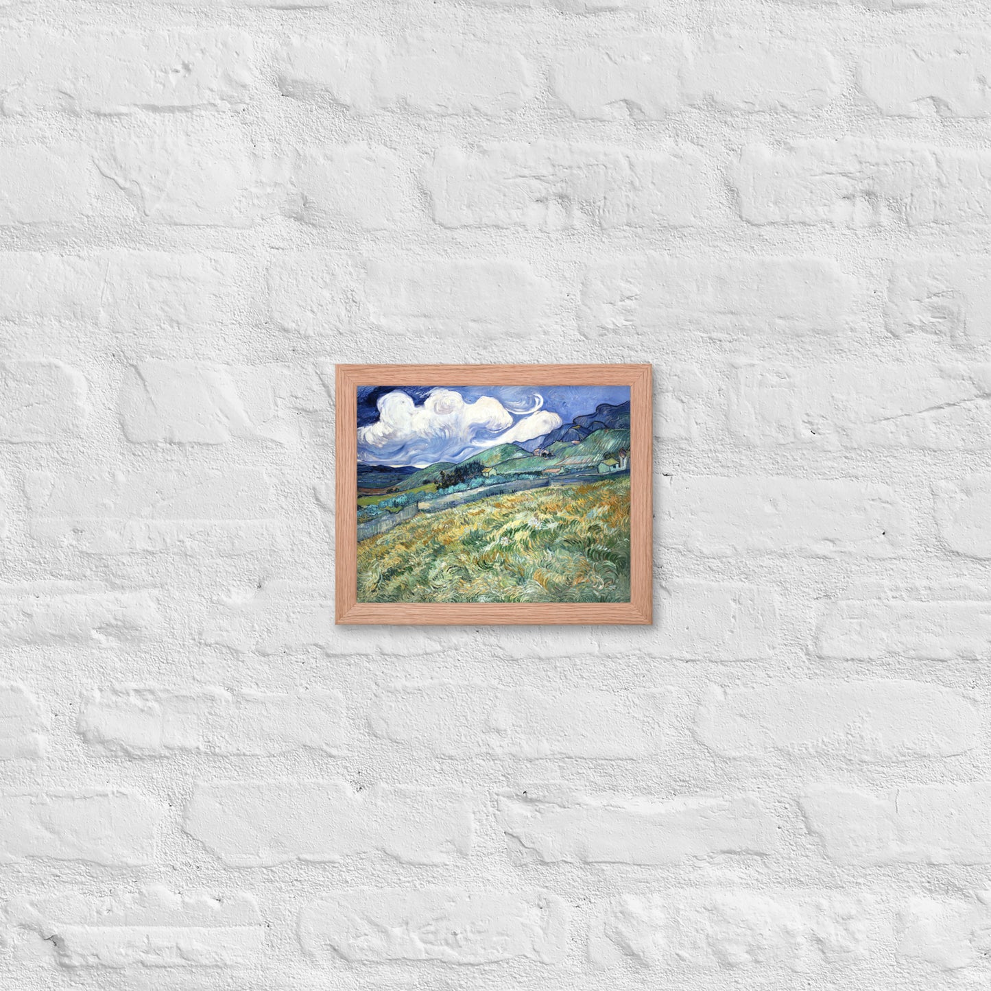 Van Gogh's 'Landscape from Saint-Rémy' on a 8"x10" red oak framed poster print on a white brick wall.